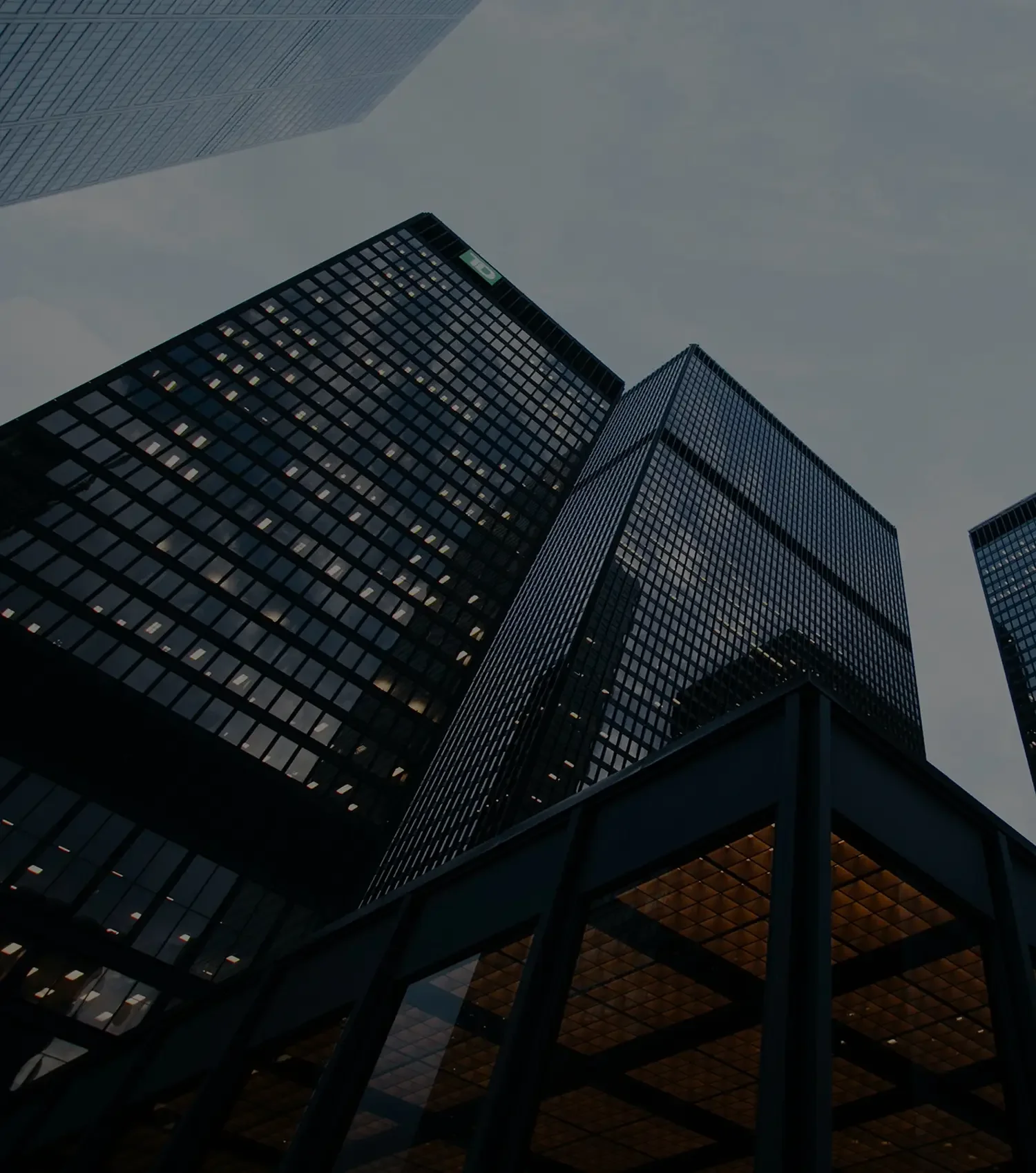 High-rise buildings seen from street level during dusk or night,