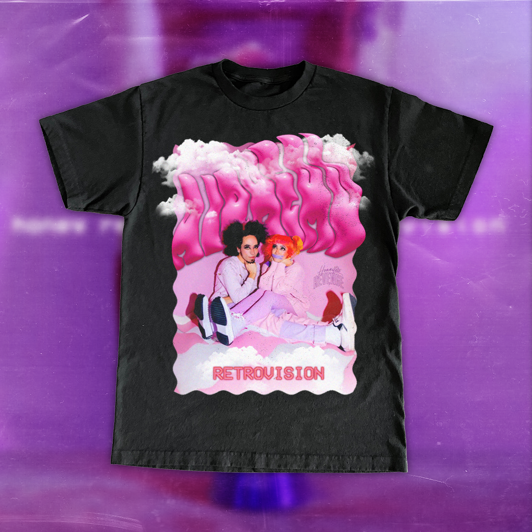 Black t-shirt featuring a graphic design of two women sitting on the ground with pink clouds and graffiti-style text that says "Retrovision" in pink, and additional smaller text that appears to say "Honestn`REVENGE".