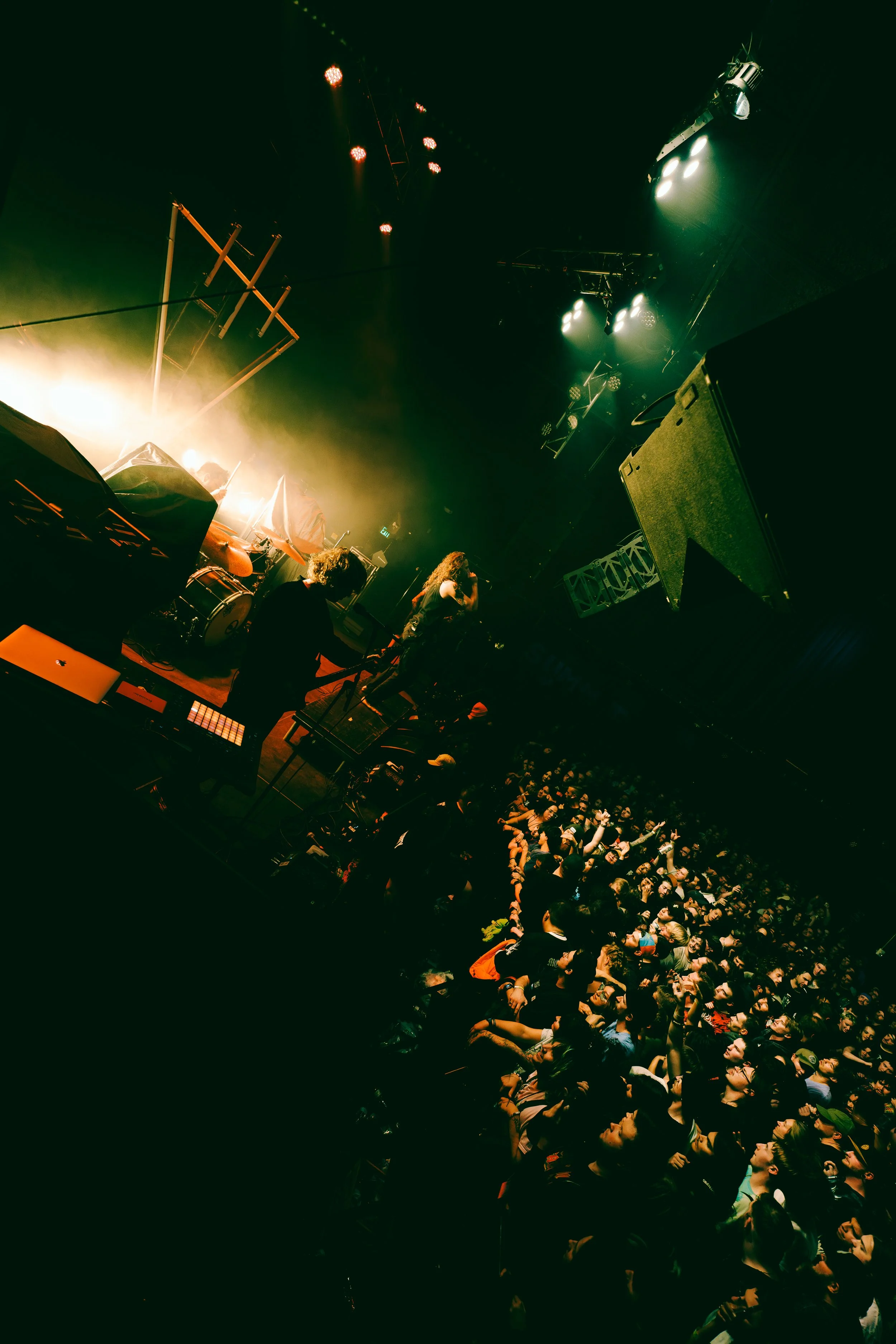 A live concert with a band performing on stage and a large audience watching.