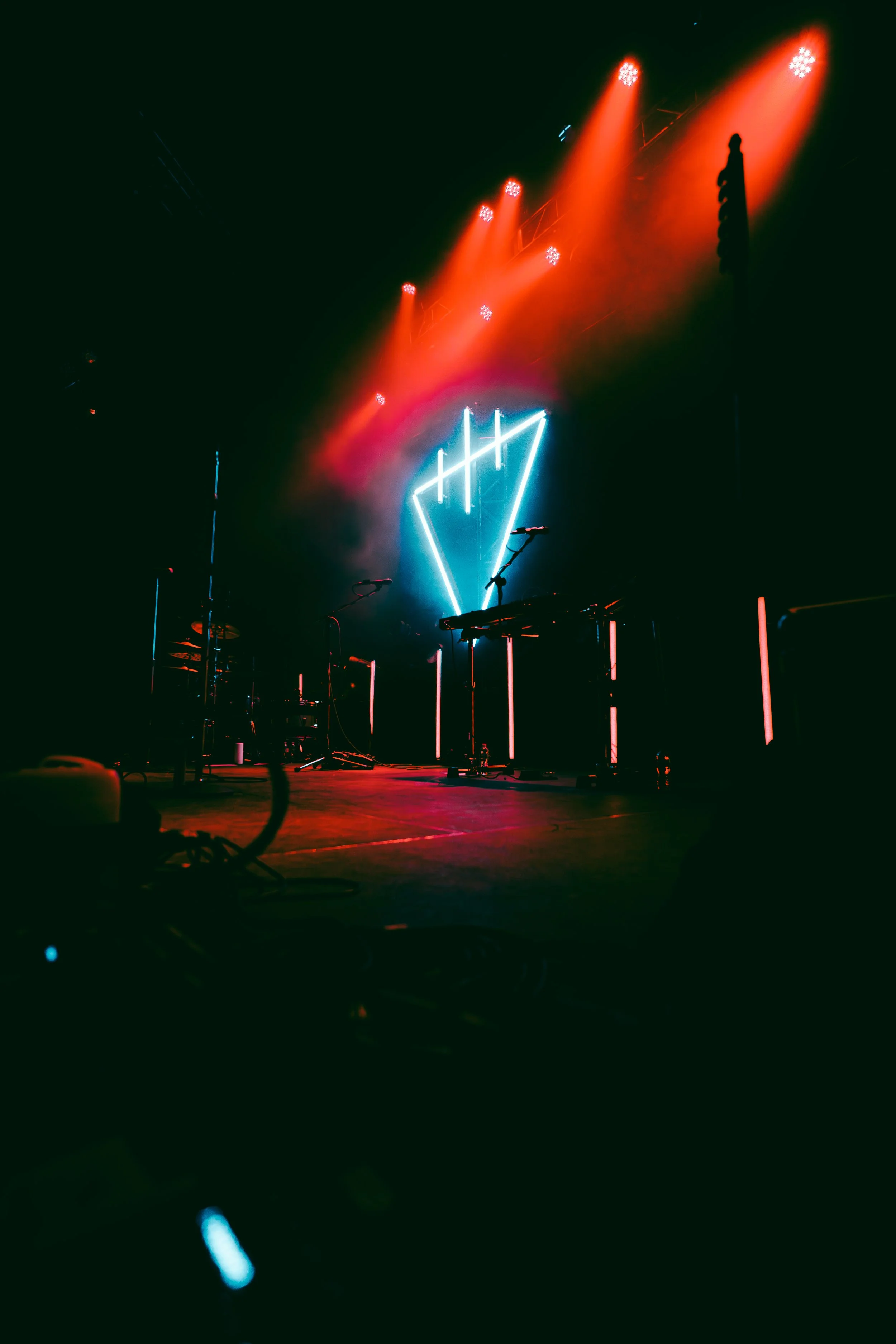 Stage with colorful red and blue neon lights, including a heart-shaped neon sign in the center, and musical instruments on the stage.