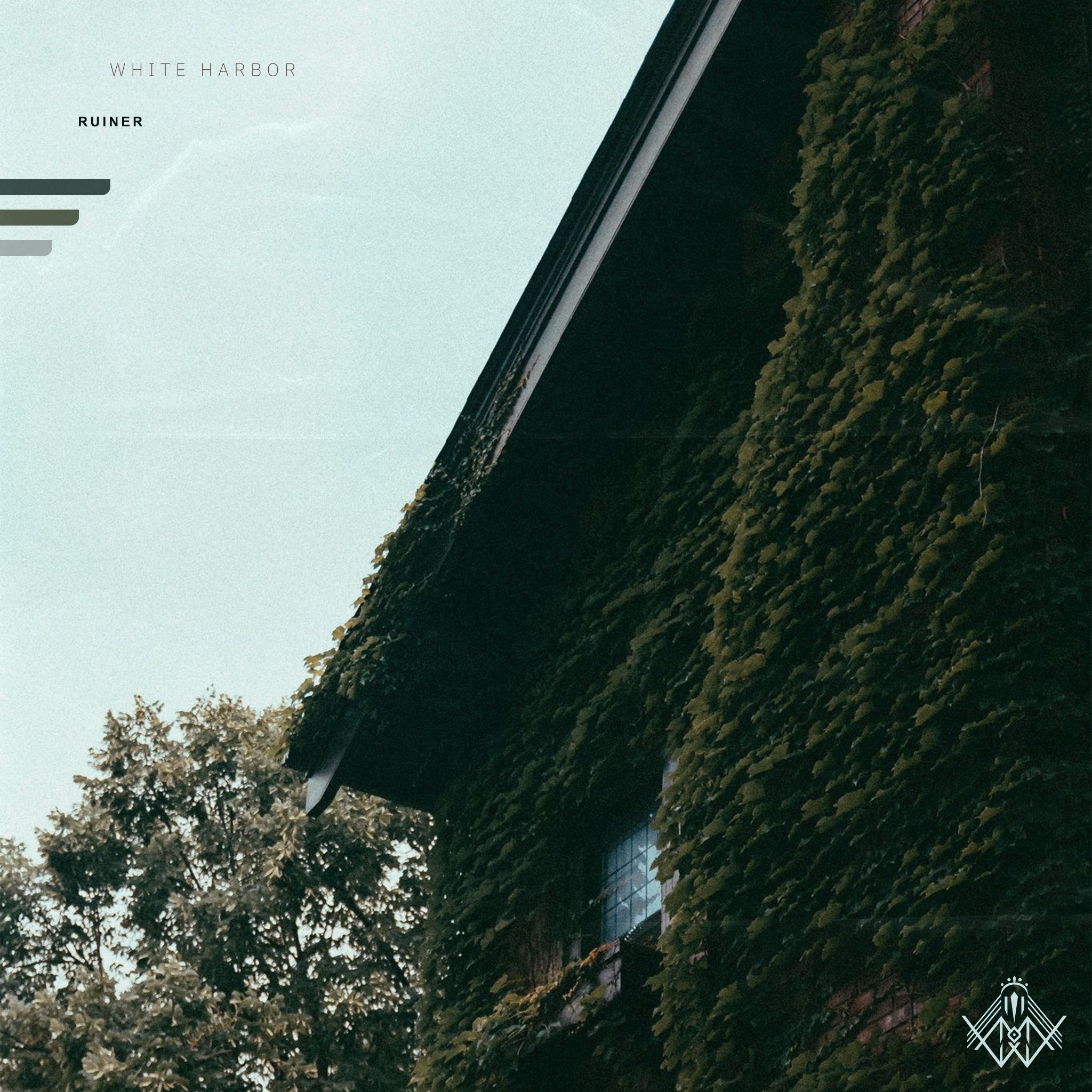 Side view of a building covered in green ivy with a dark roof and a window partly visible, trees in the background, and a clear sky.