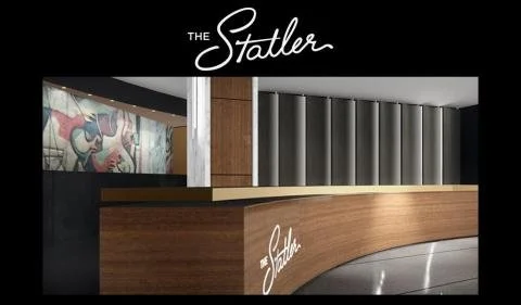 Reception desk with a wooden front and a black top at The Statler hotel.