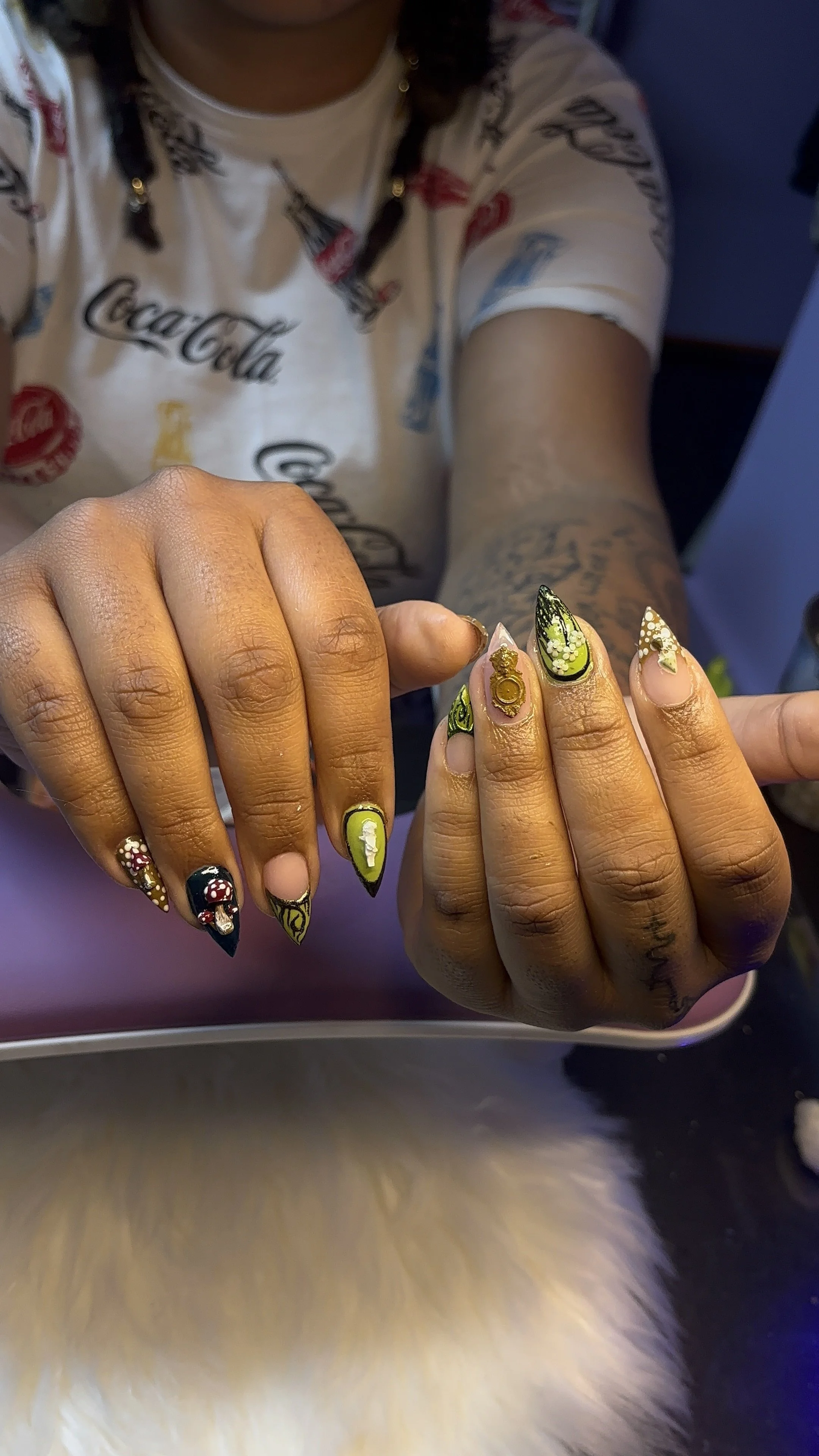 Close-up of a person's hands with elaborately decorated nail art, featuring colorful and detailed designs.