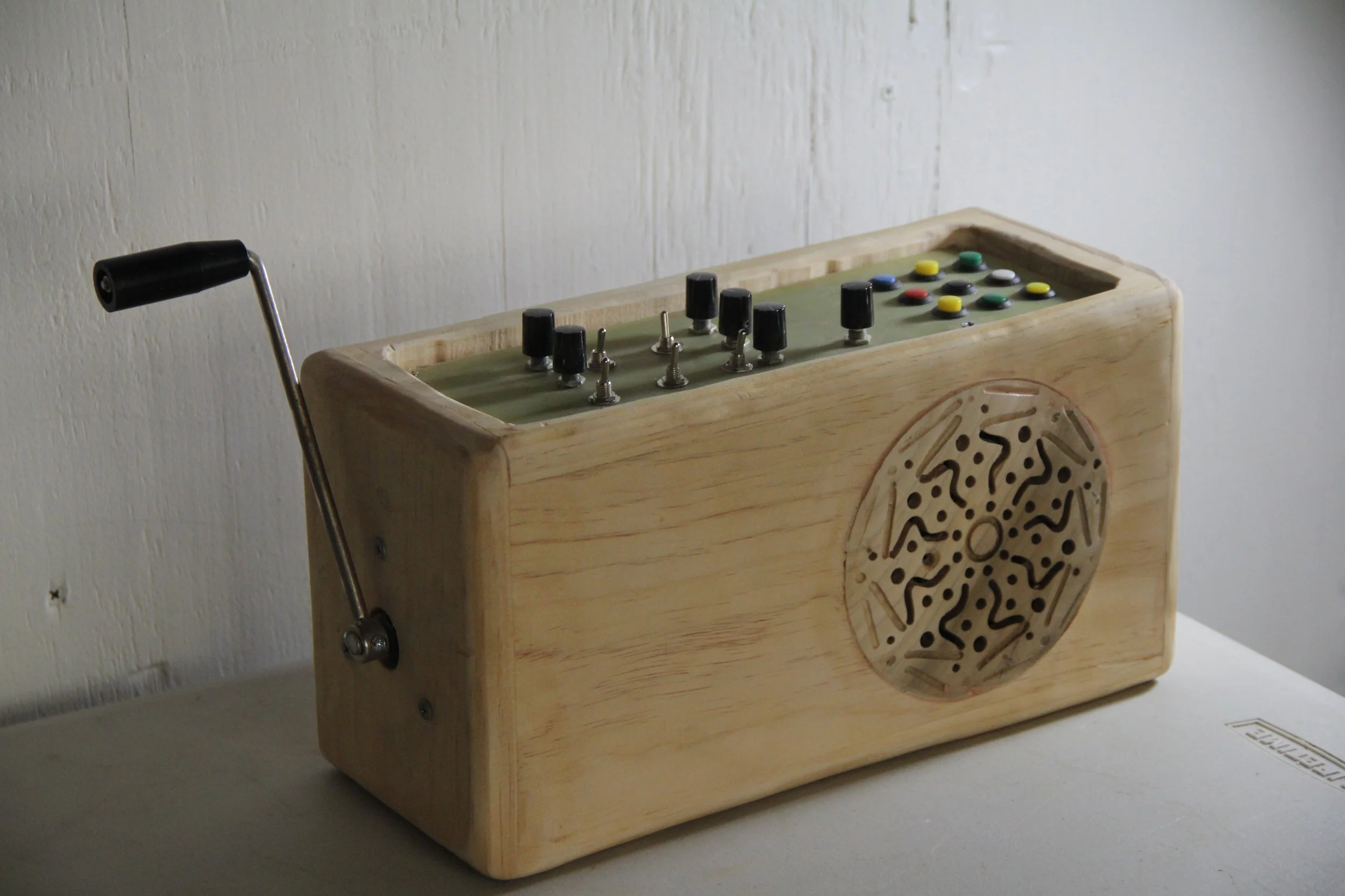 A vintage-style wooden arcade game with a joystick on the left and a control panel with buttons and knobs, placed against a plain wall.