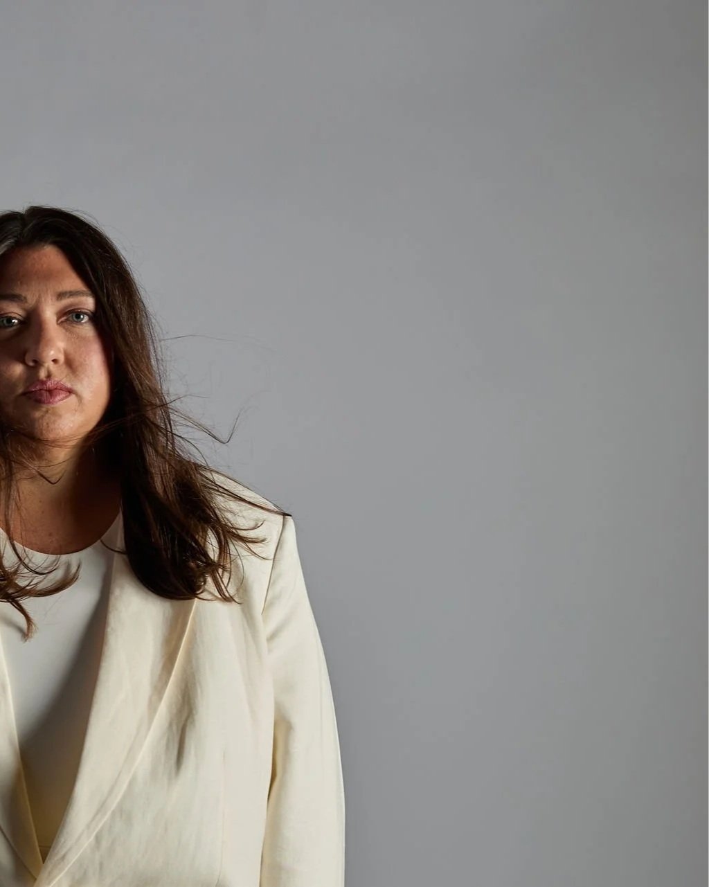 Tanya Jacobson, Capacity advisor that removes founder dependency and expands capacity for scaling founders, wearing a cream-colored blazer against a plain gray background.
