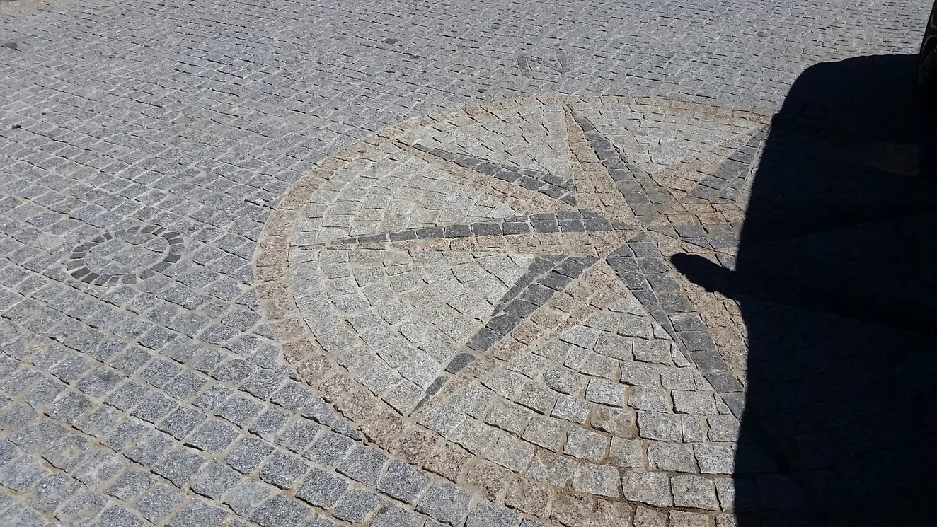 Paving stones arranged in a fountain design with the Mercedes-Benz logo in the center of a circular pattern.