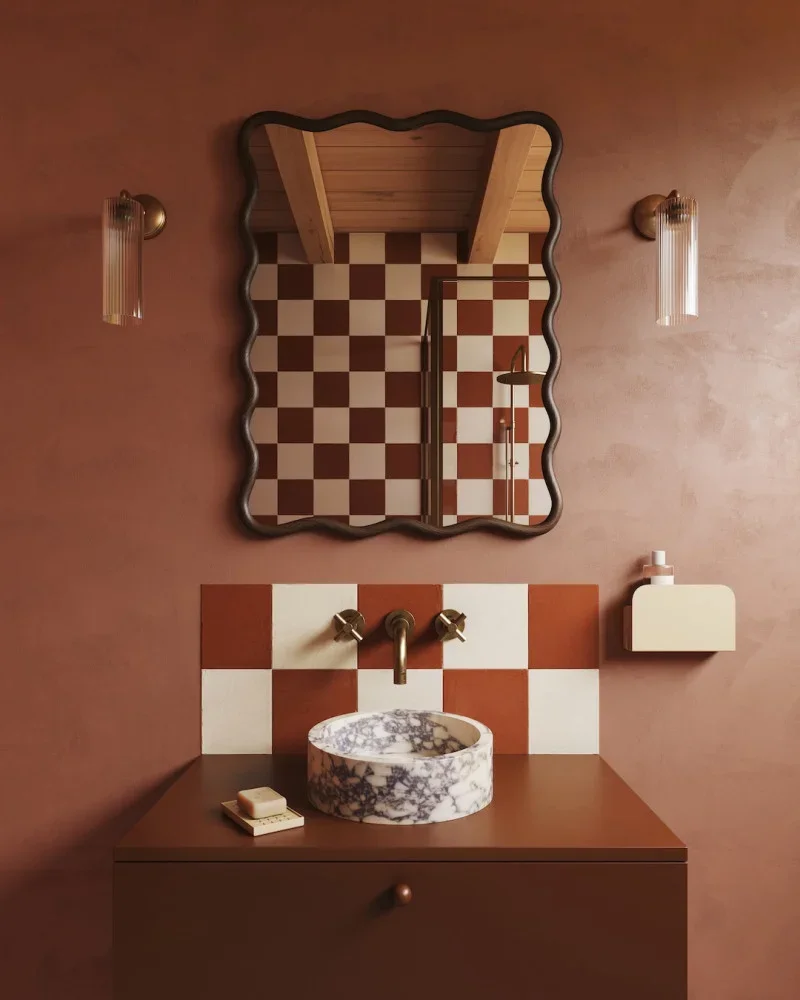 A burgundy bathroom with a marble sink on top a wooden vanity 