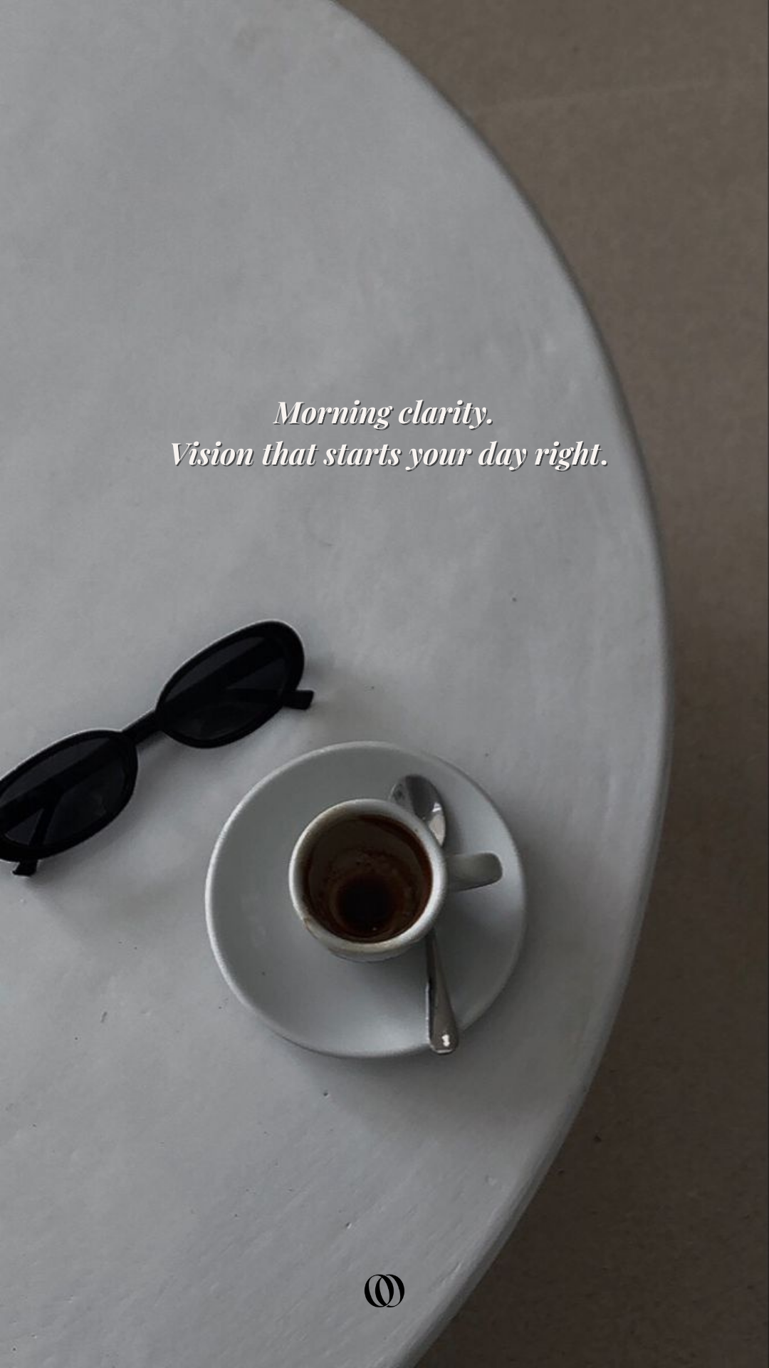 A white oval table with black sunglasses, a small white coffee cup with coffee on a matching saucer, and a metallic spoon. Overlaid text reads: 'Morning clarity. Vision that starts your day right.'