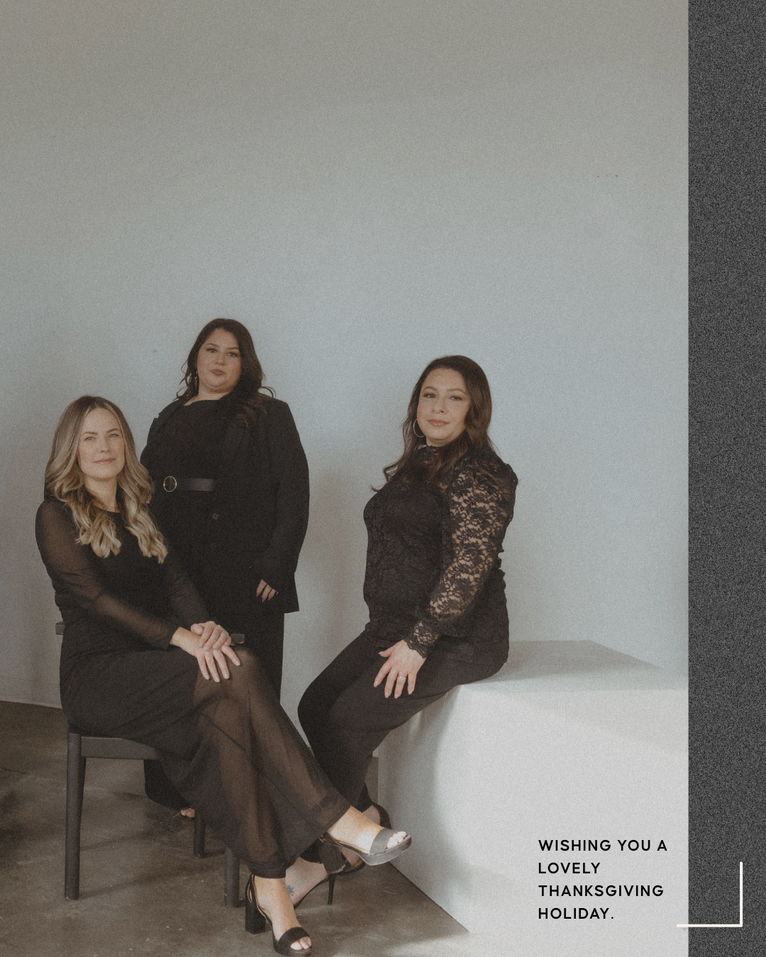 Three women dressed in black, posing against a plain background with a Thanksgiving holiday greeting on the bottom right.