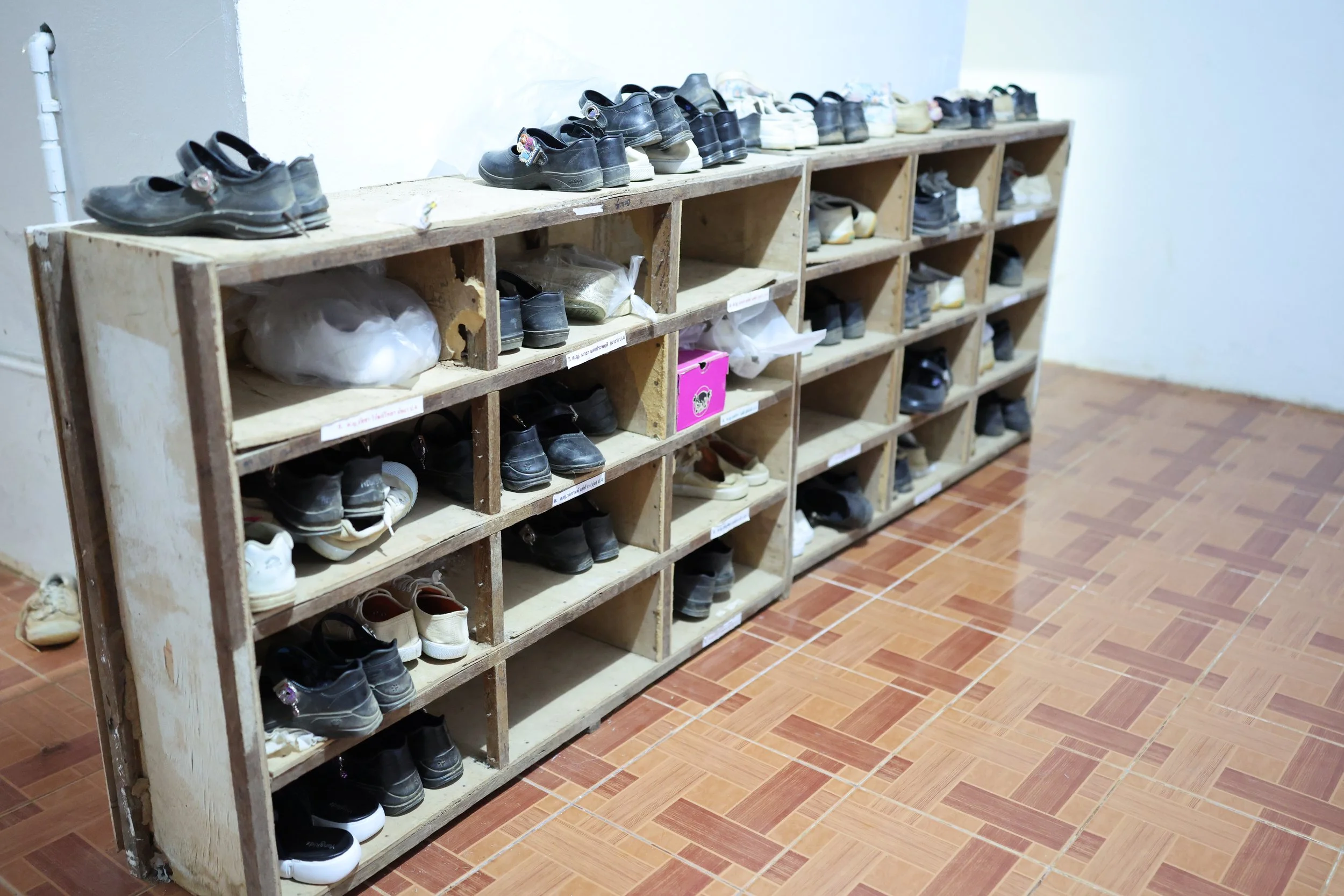 Current Shoe Storage Area – To keep the dorm clean and sanitary, shoes are not allowed inside the living spaces. These racks provide outdoor storage for the girls' footwear.