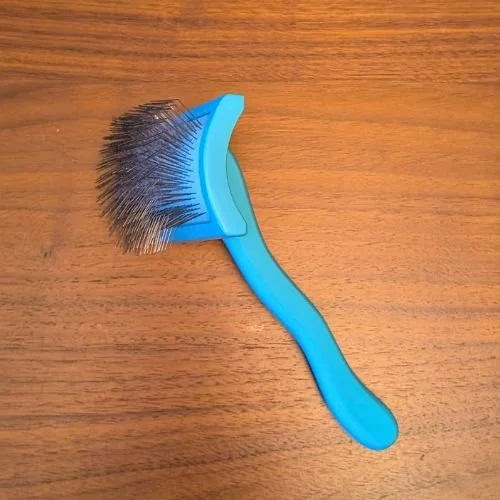 Chris Christensen Big G Slicker Brush in teal on a wooden background