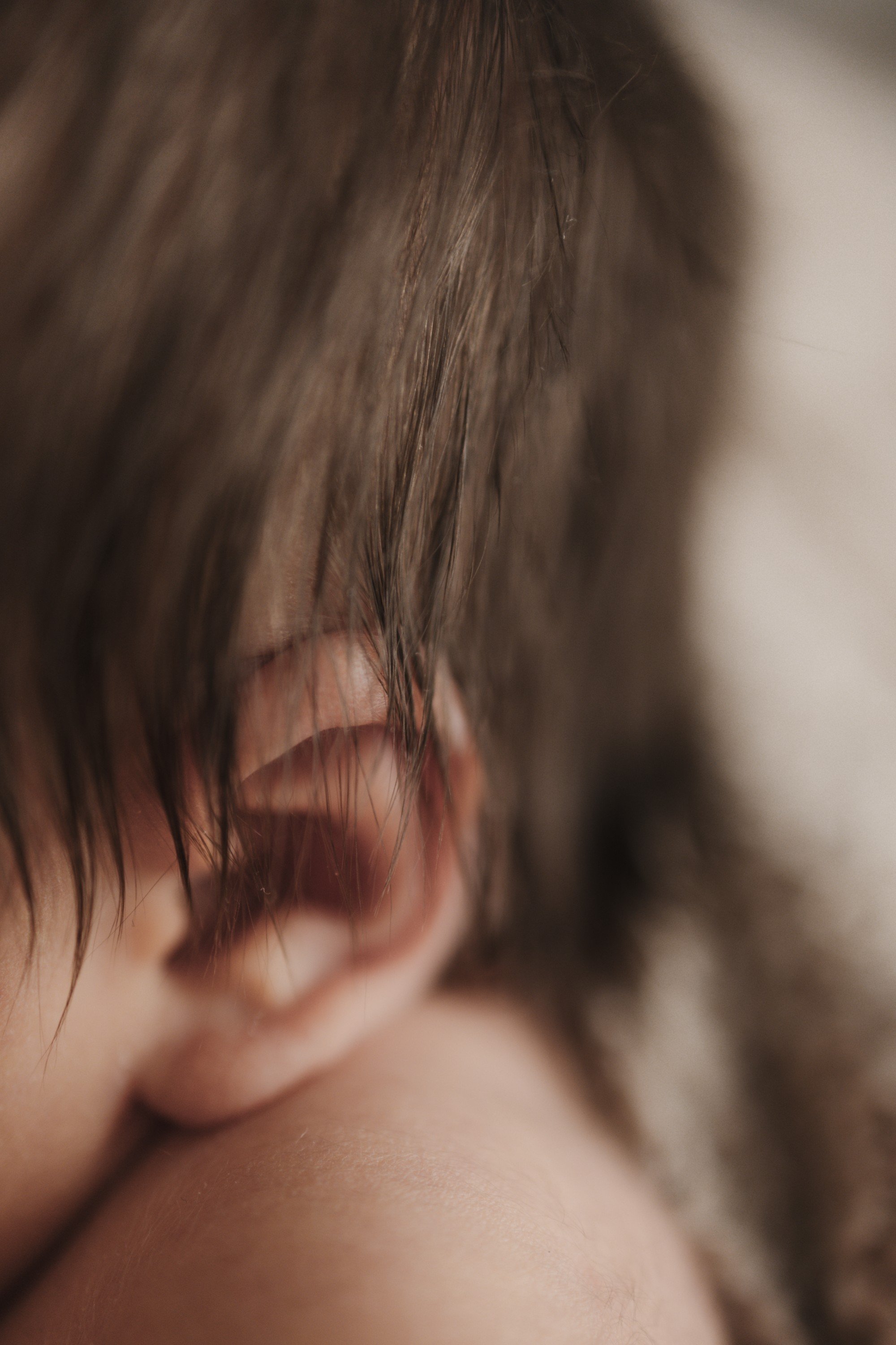 Close-up of a sleeping baby's face, focusing on the tiny nose, closed eyes, and chubby cheeks.