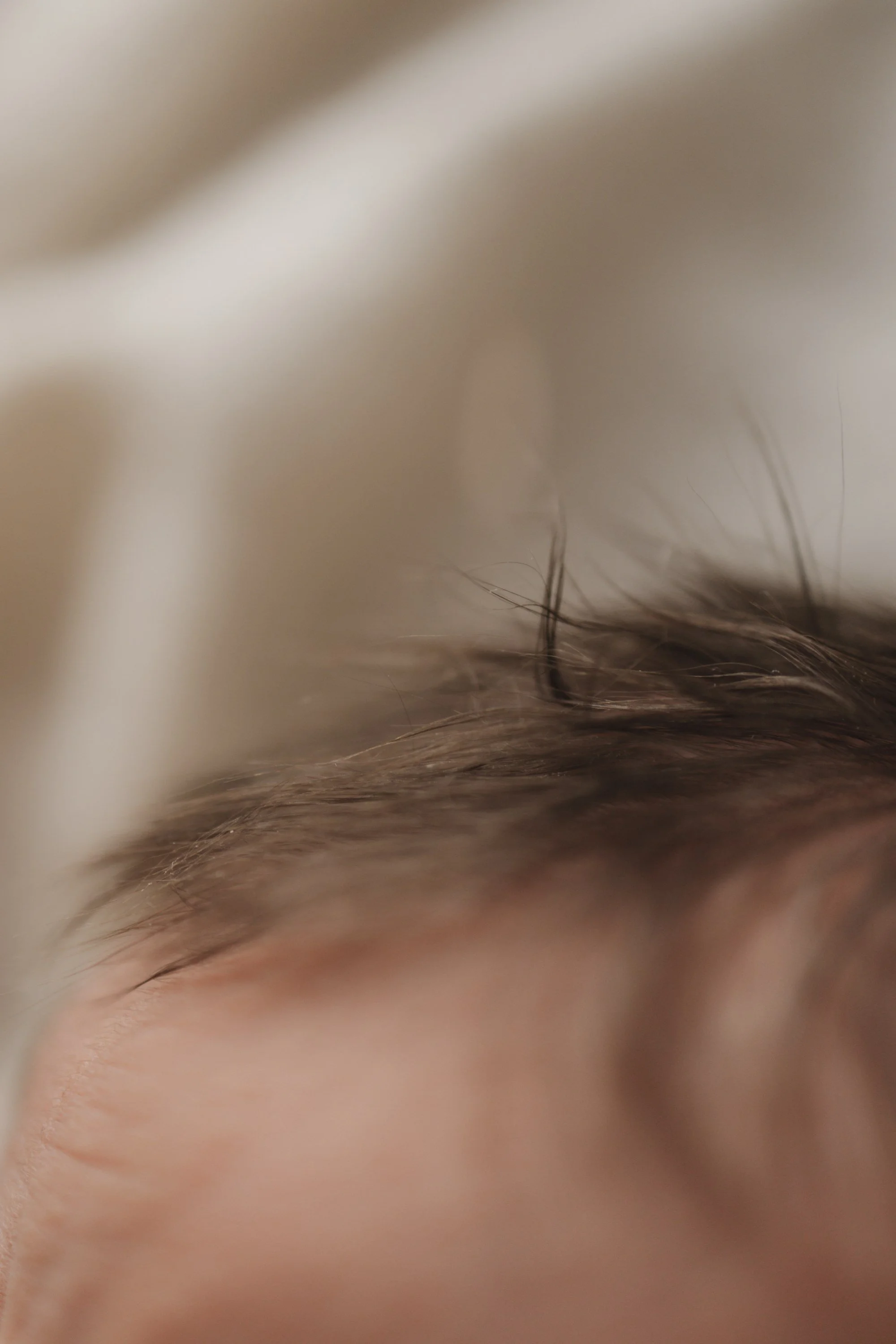 Close-up of a person's closed eye and surrounding skin.