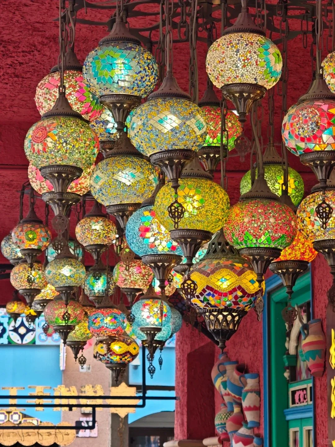 Colorful mosaic Turkish-style hanging lamps suspended from a ceiling.