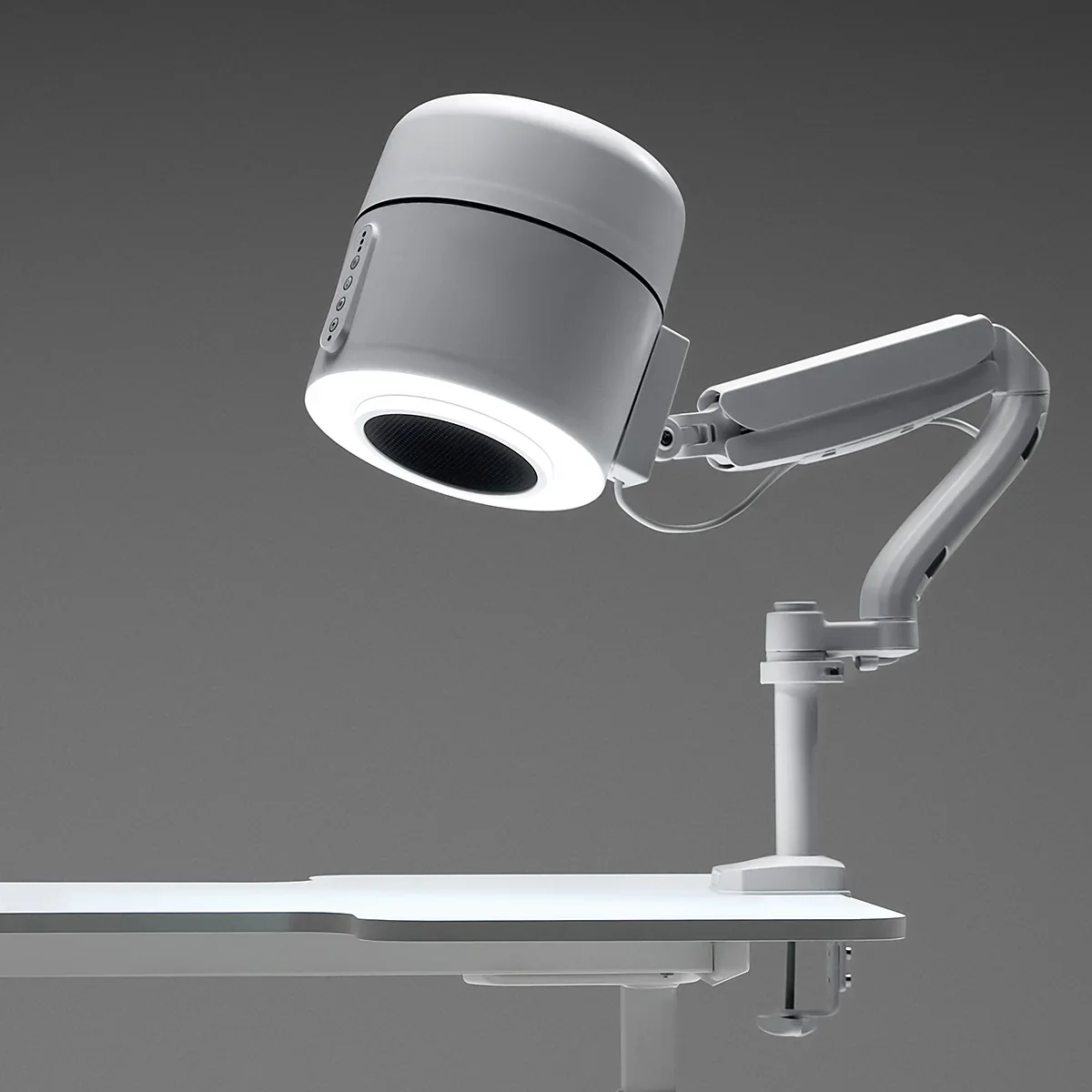 A modern dental or medical overhead lamp attached to an adjustable arm over a white table or tray.
