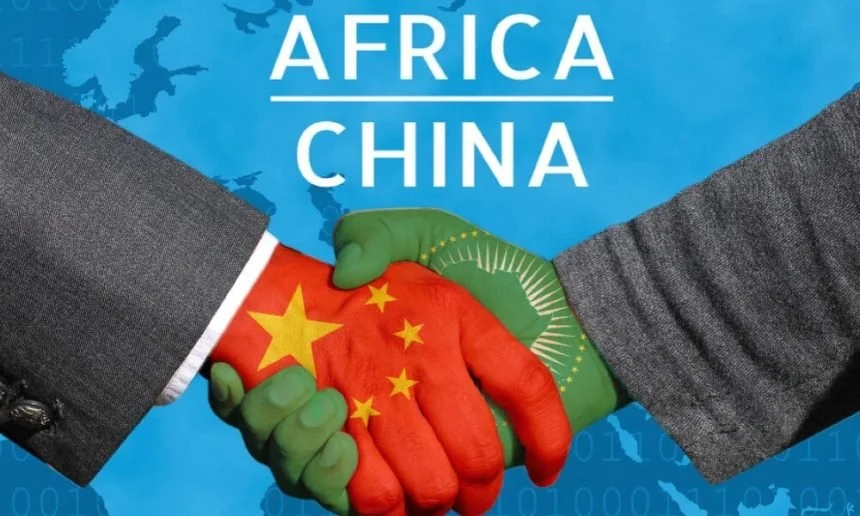 A handshake between two people with one hand painted as the Chinese flag and the other as the African map, with the text 'Africa China' above them, symbolizing cooperation between Africa and China.