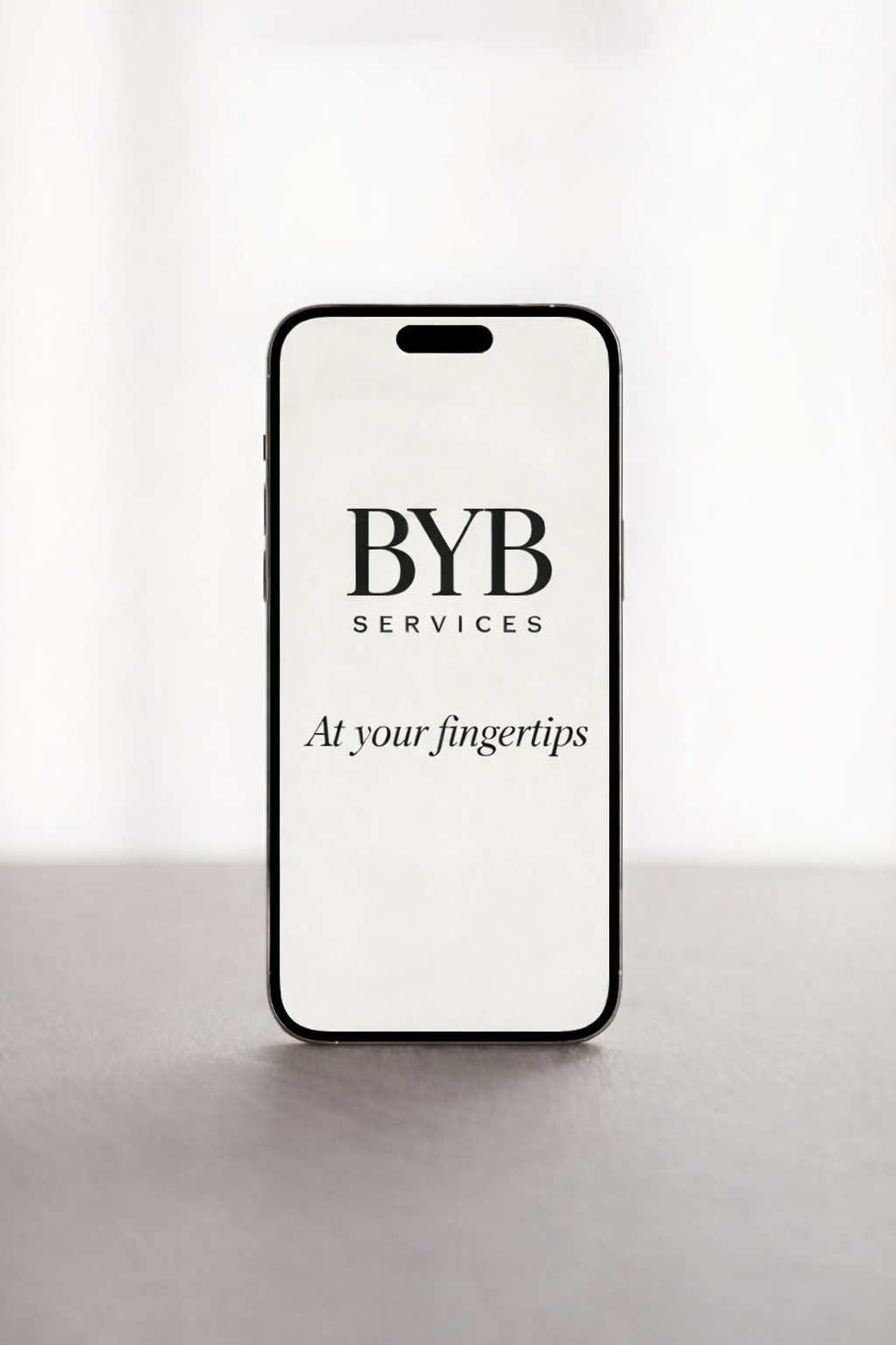 Smartphone displaying the BYB Services logo with the tagline ‘At your fingertips’.