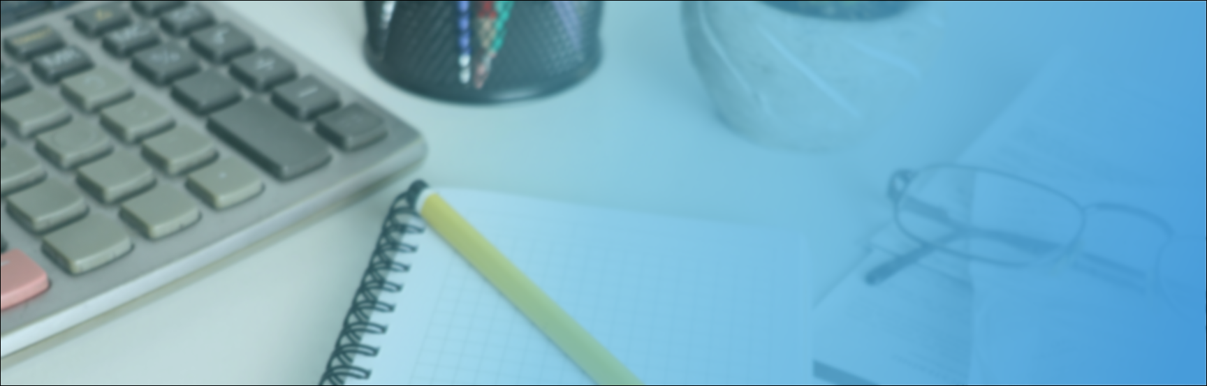 Office desk with computer keyboard, notebook with a yellow pen, glasses, and a container with pencils and pens