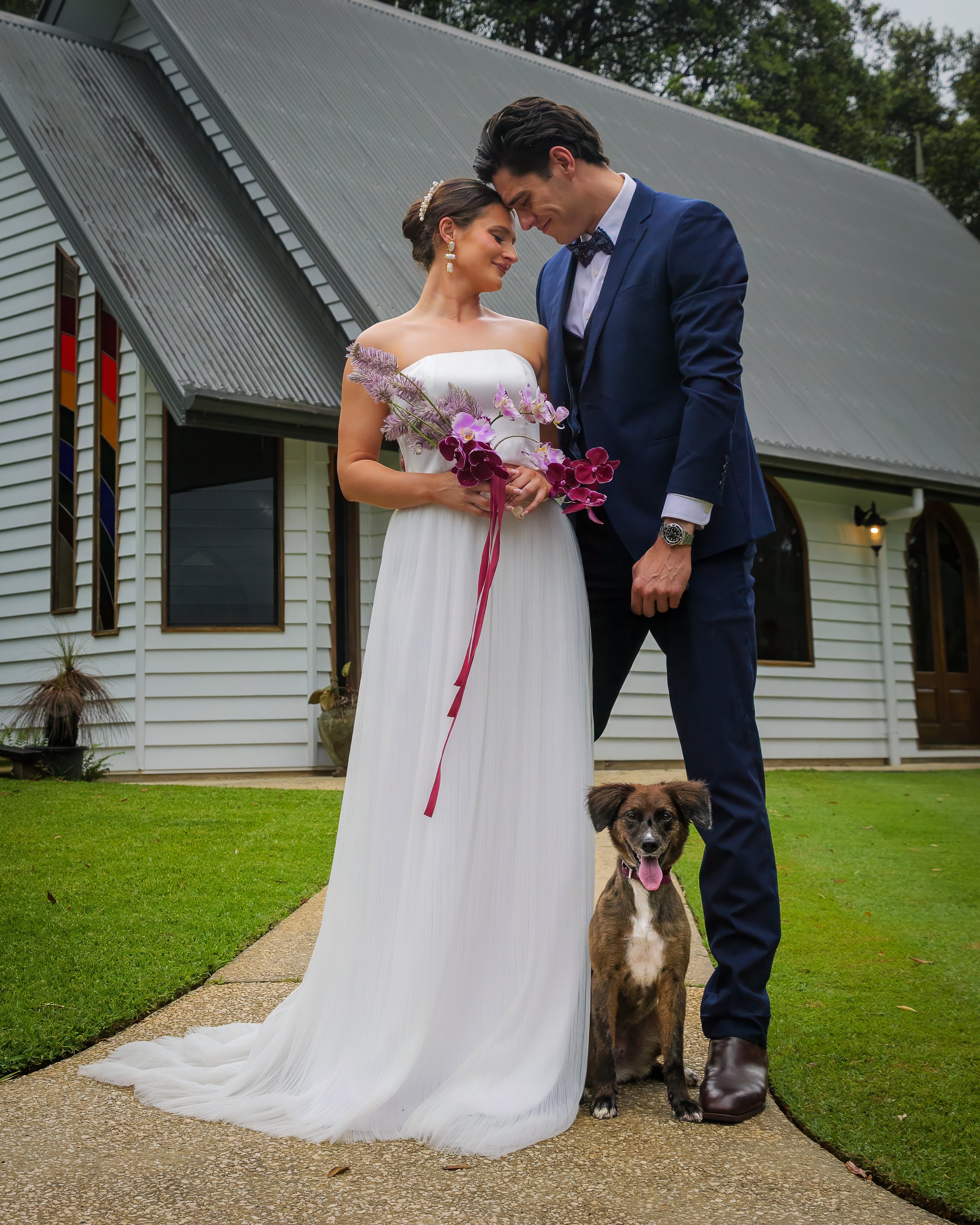 Dog with bride and groom posing for photos at Prideaux Estate Sunshine Coast