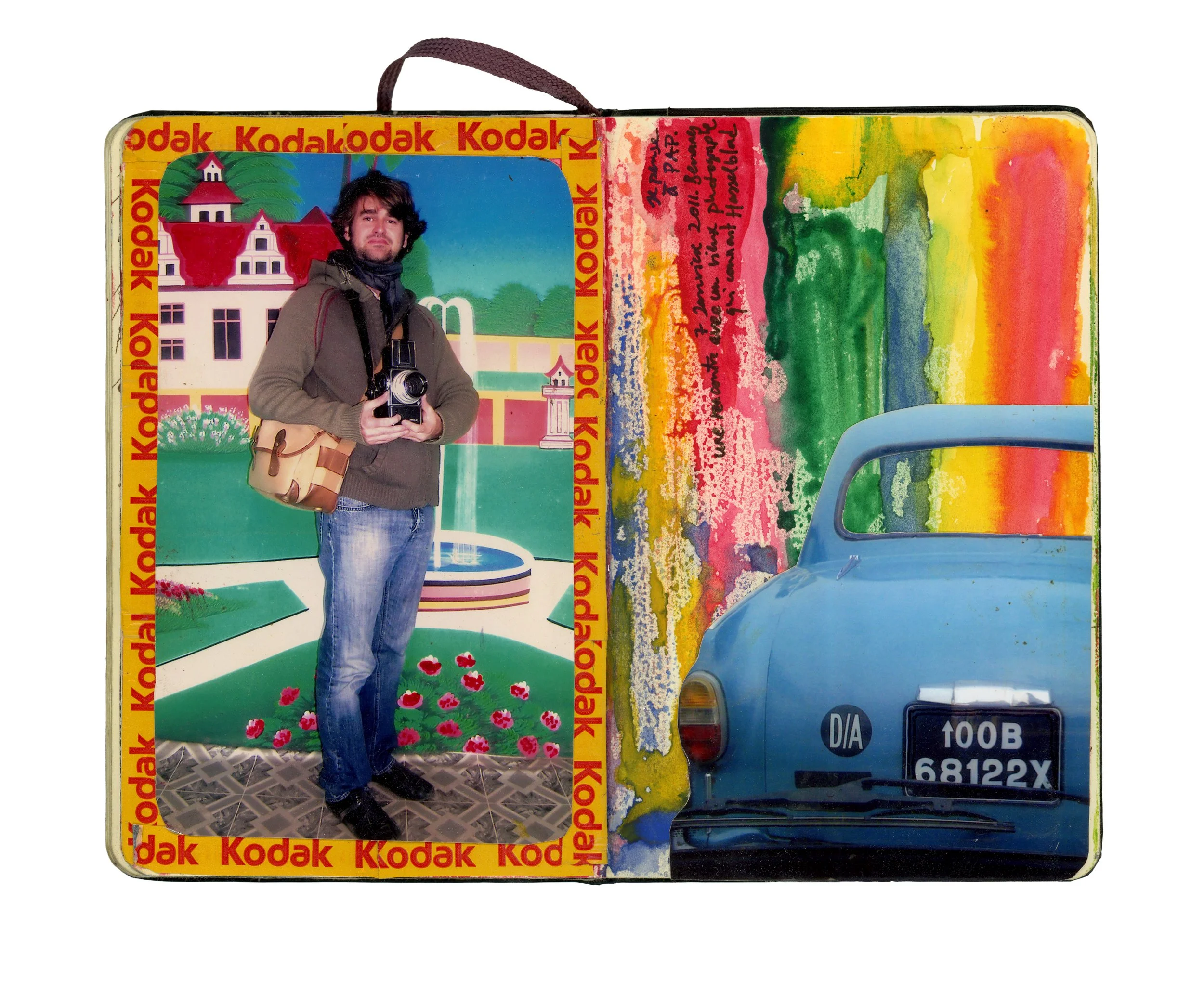 Open Kodak photo album with a picture of a man holding a camera, colorful painted background, and a blue vintage car in a painting.