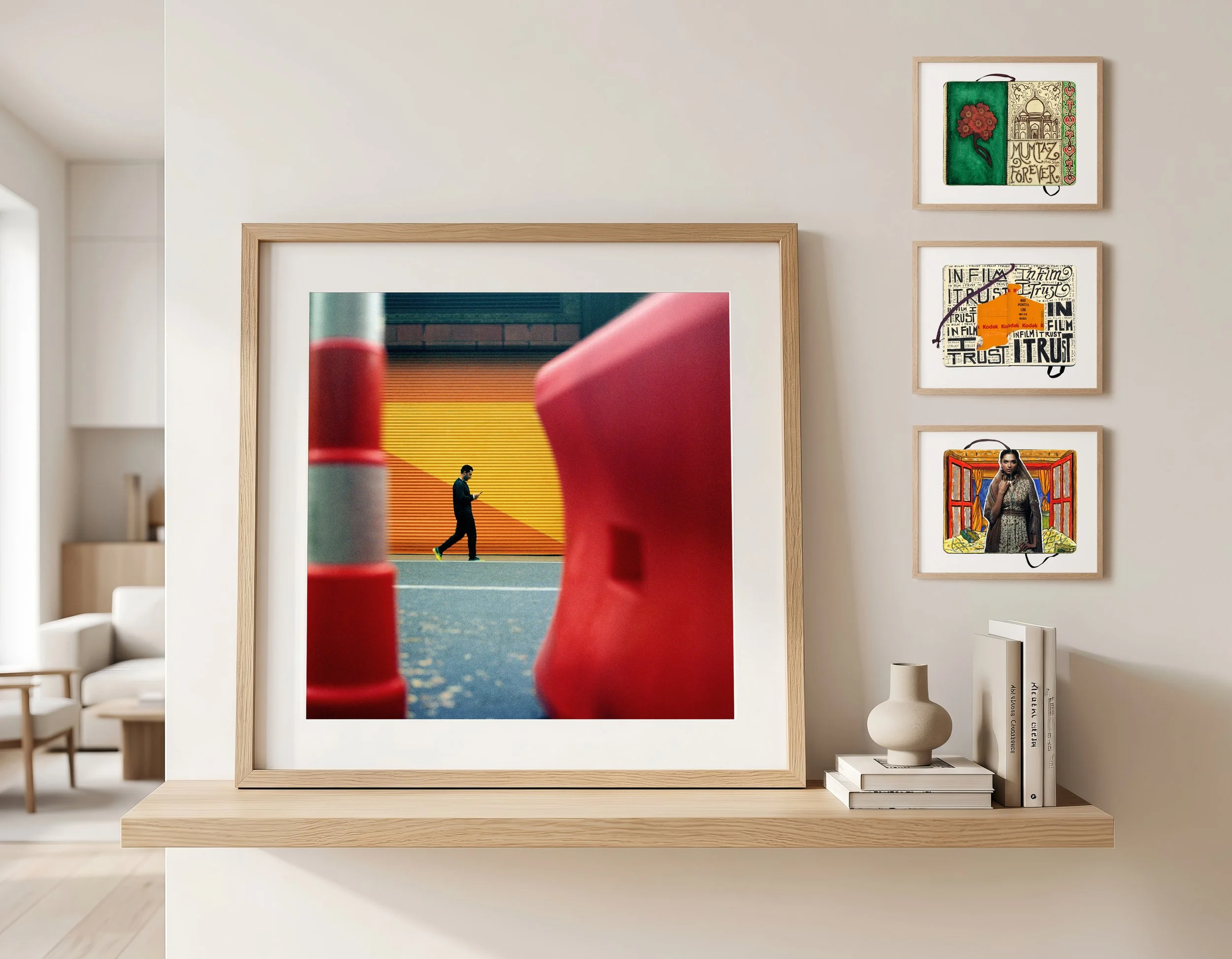 Living room with framed artwork on wall, decorative items on shelf, and a large picture on display.