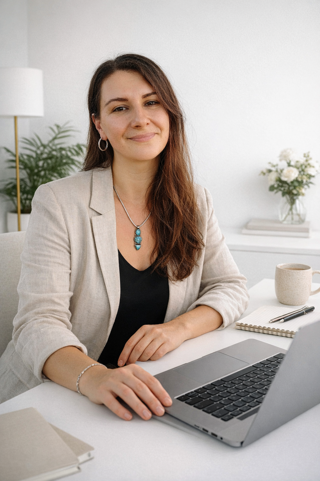 Cat, web designer at Mama Design Studio, working on a laptop in a clean, neutral environment.