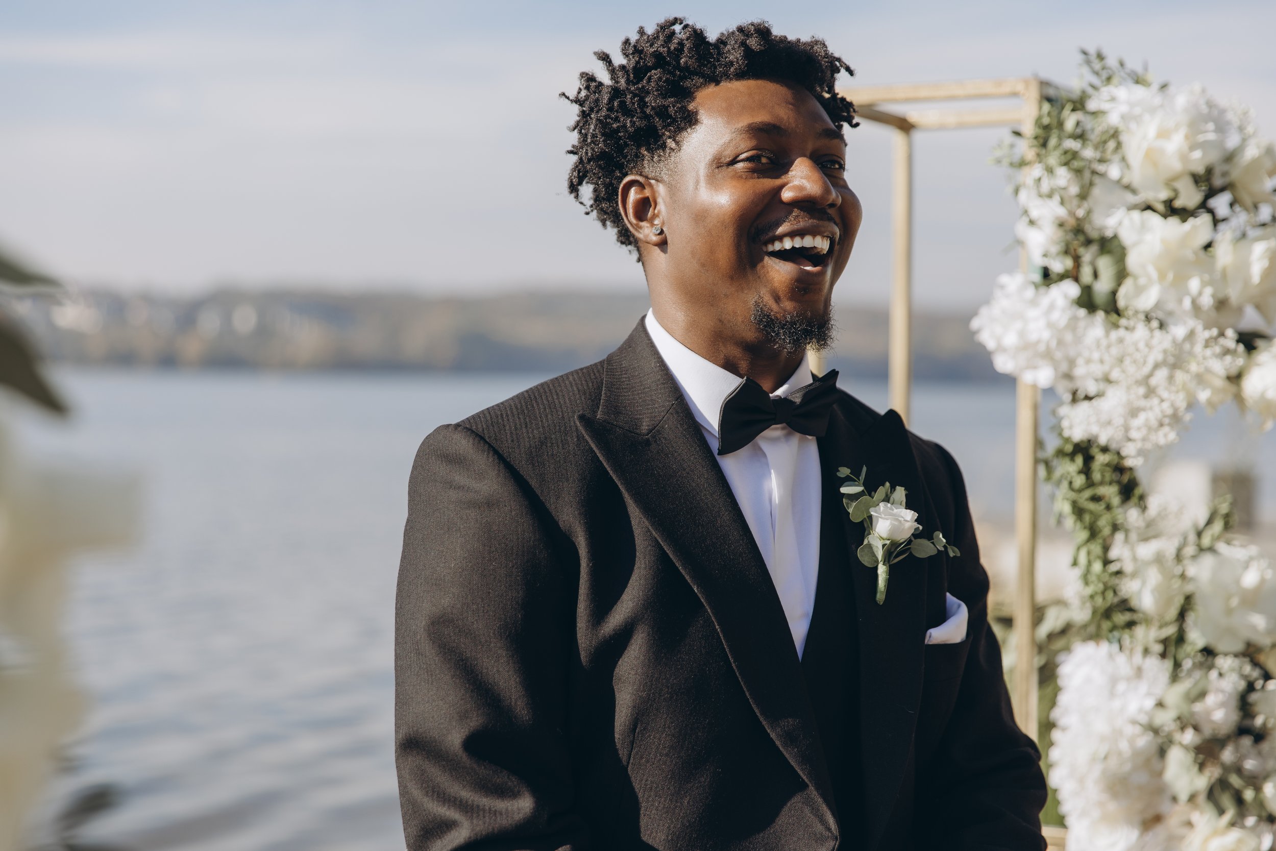 groom-laughing-during-wedding-ceremony-by-the-lake-2026-01-08-02-08-07-utc.jpg