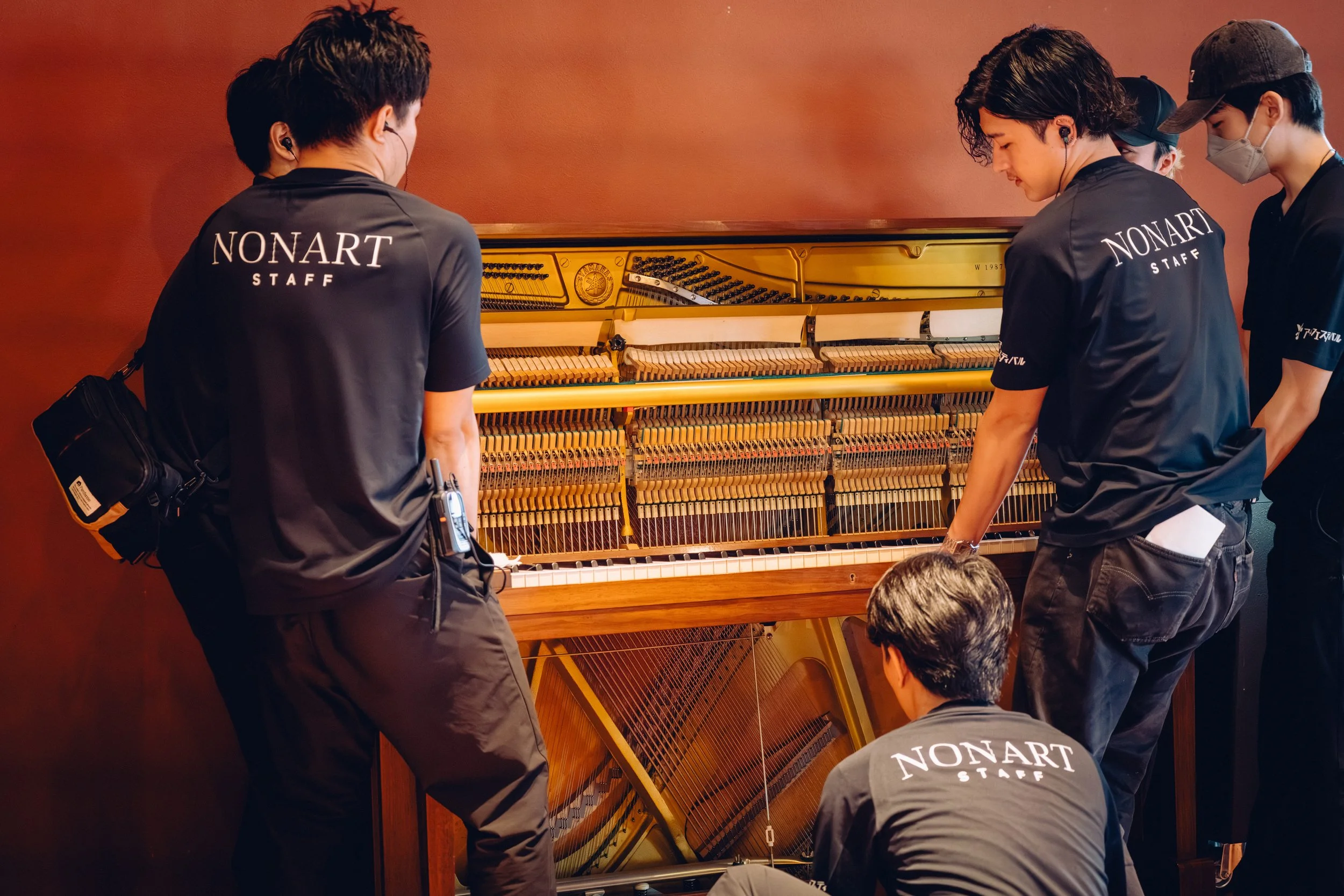 ピアノの内部を修理または調整しているスタッフのグループ