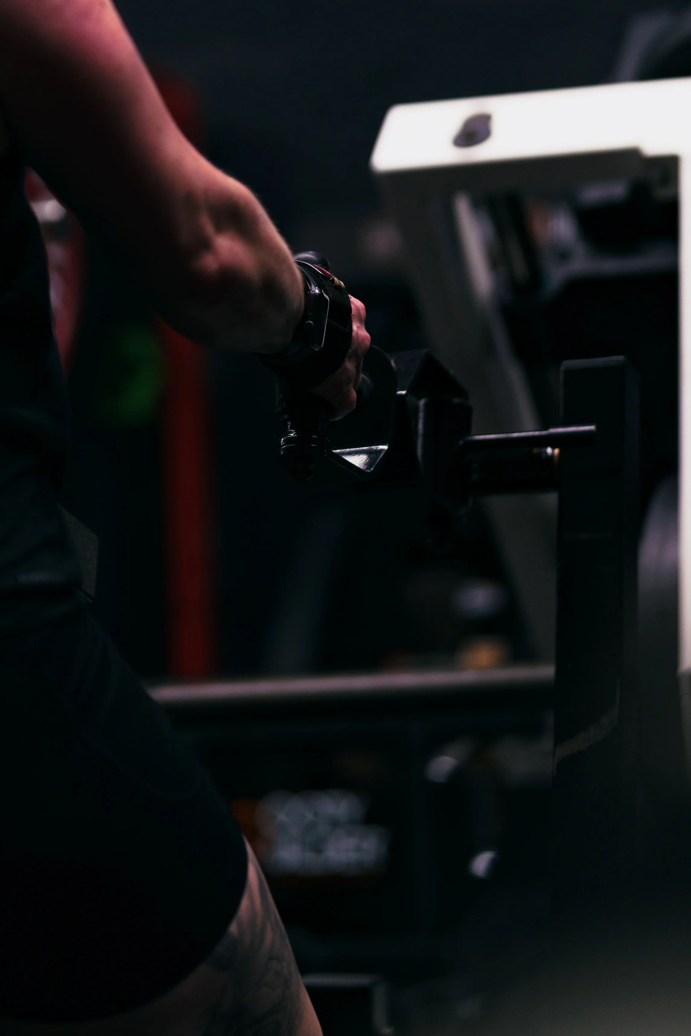 A person in a dark environment, with part of their arm and torso visible.