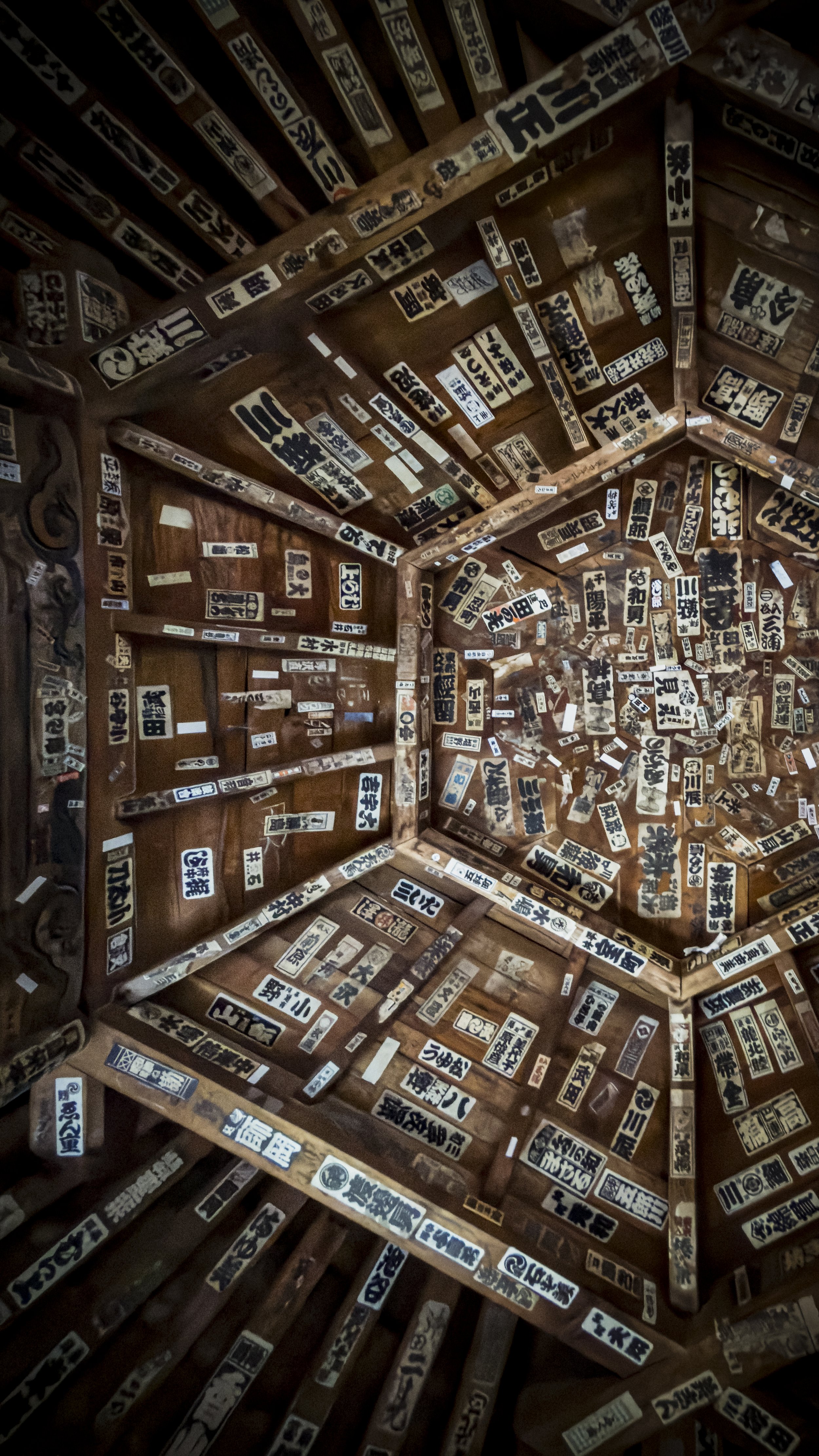 Interior of a wooden room decorated with numerous vintage Japanese signs and labels on the walls and ceiling.