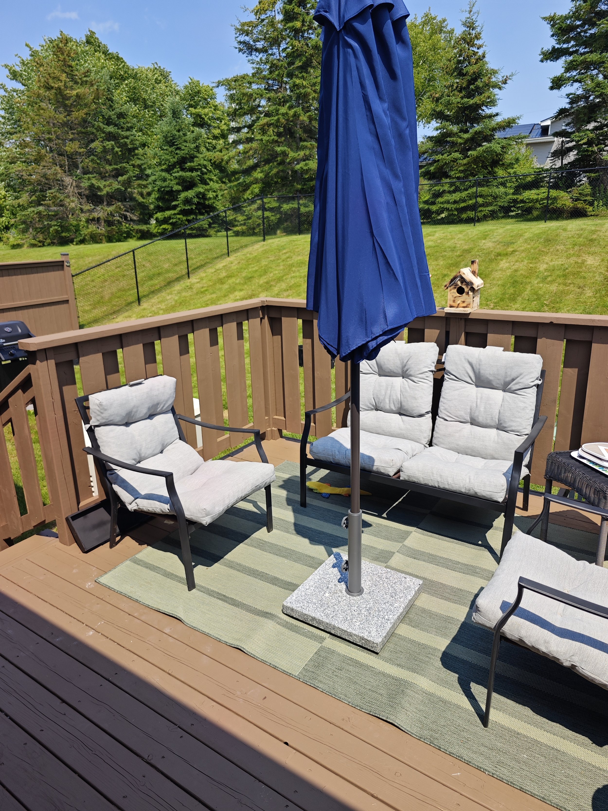 Cozy backyard deck refresh in Charlottetown, PEI. Outdoor patio furniture was assembled and arranged, with the patio umbrella securely installed for a comfortable and inviting outdoor living space. Another quality project completed by Paul Handyman P