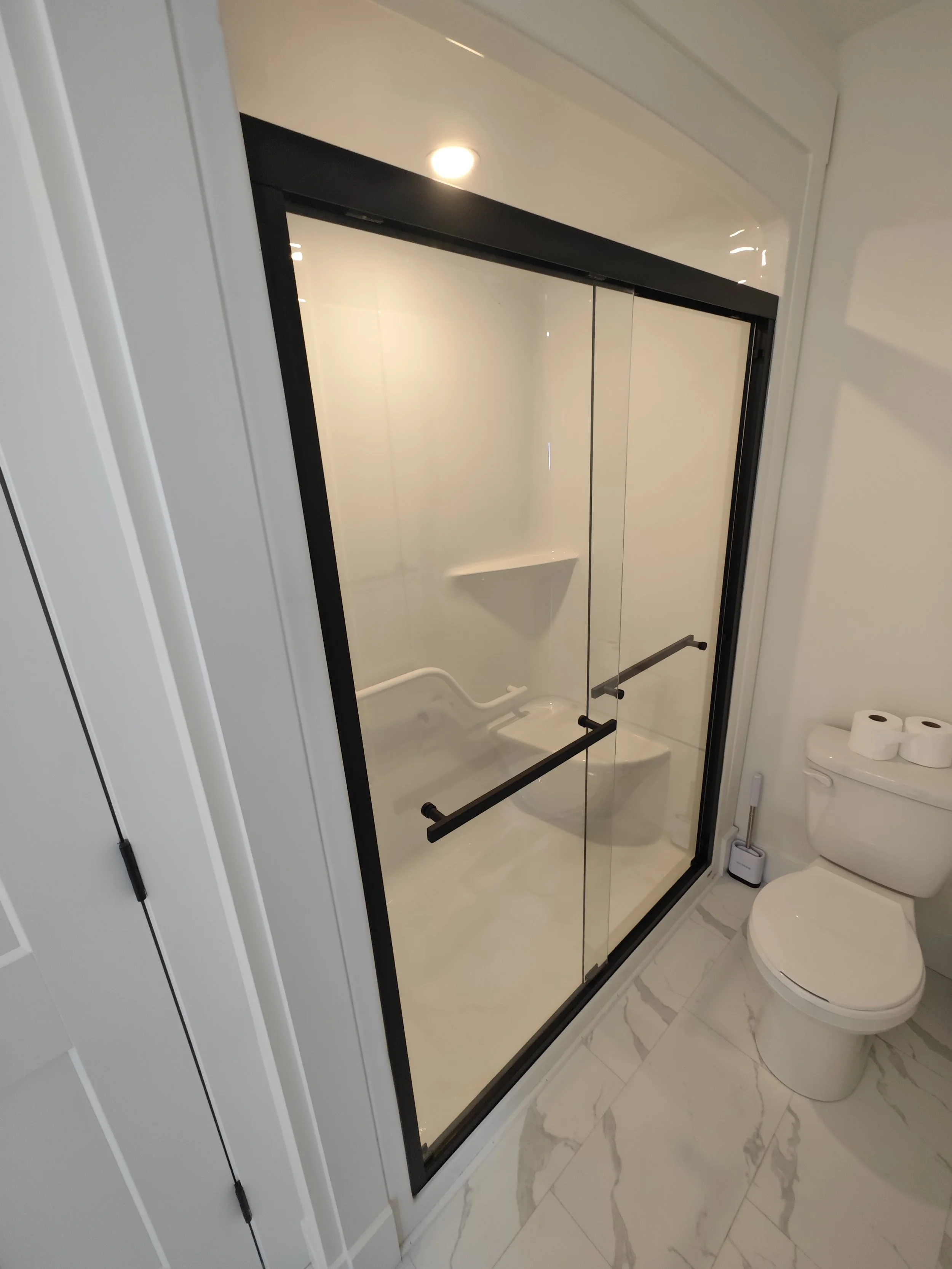 Frameless sliding shower door installation completed with precision fitting and waterproof sealing in Cornwall, PEI.