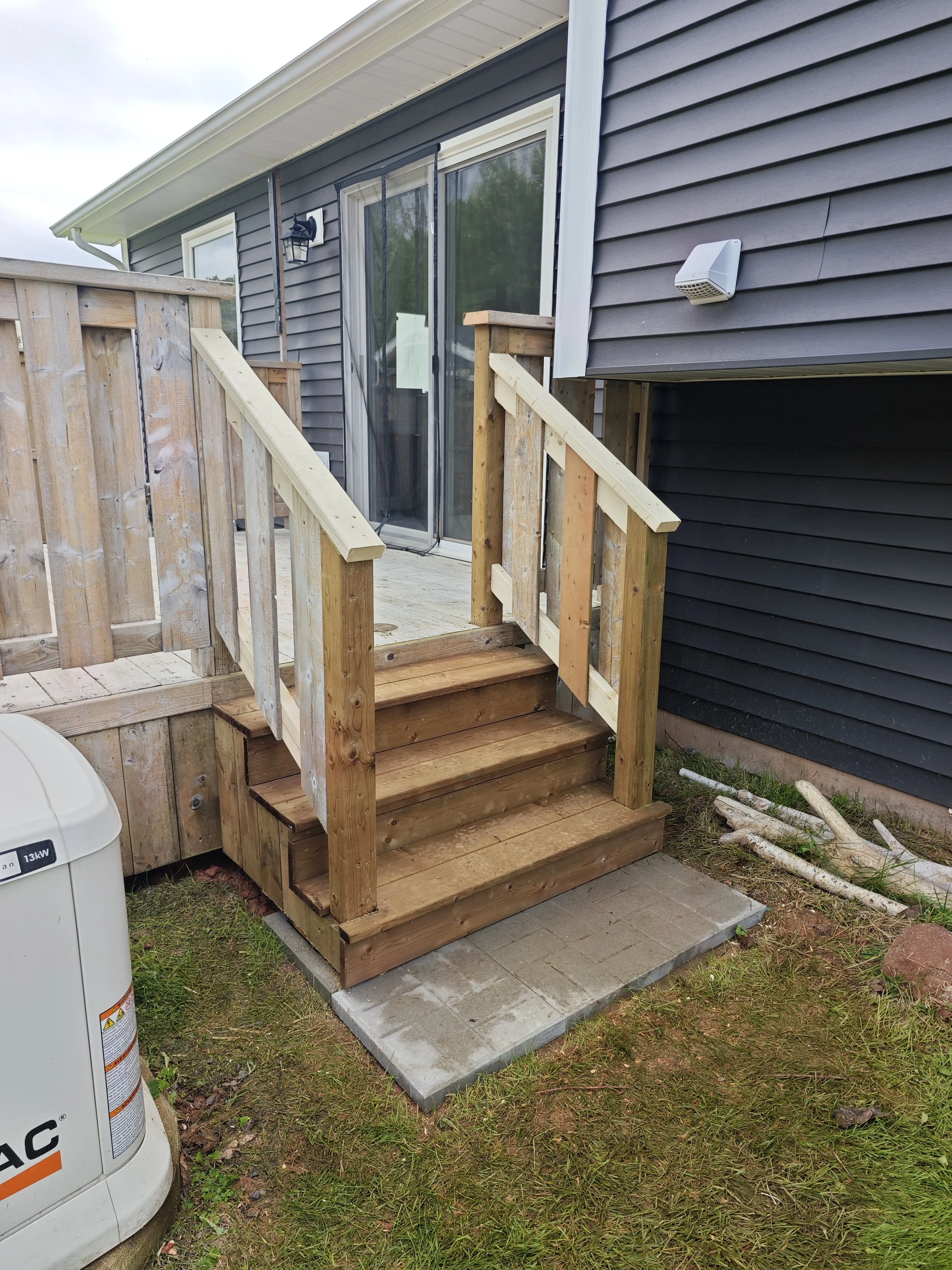 Custom pressure-treated deck stairs and handrail construction in Stratford, PEI.