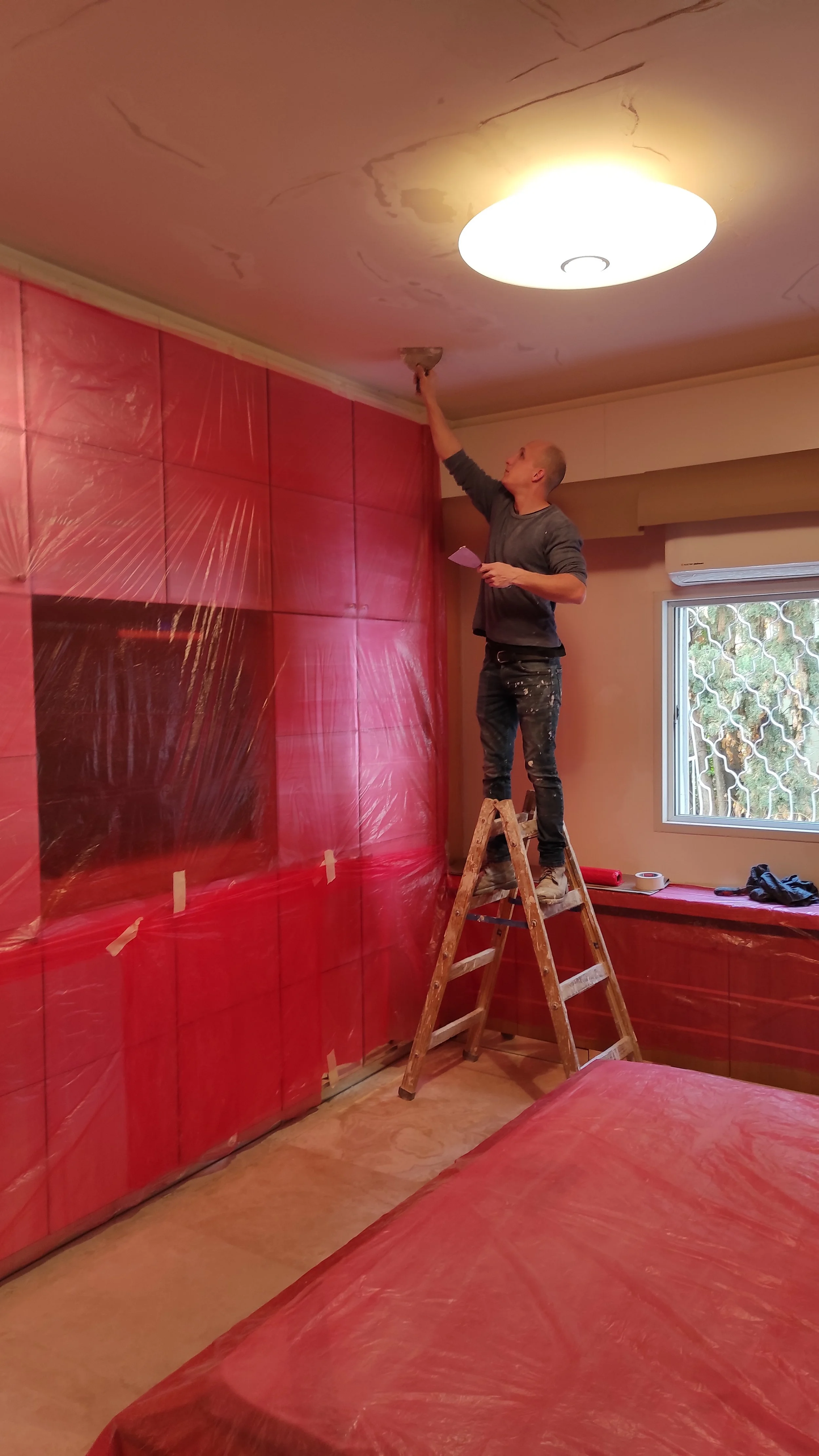 Bedroom ceiling painting in progress with full surface protection for a residential project in Halifax