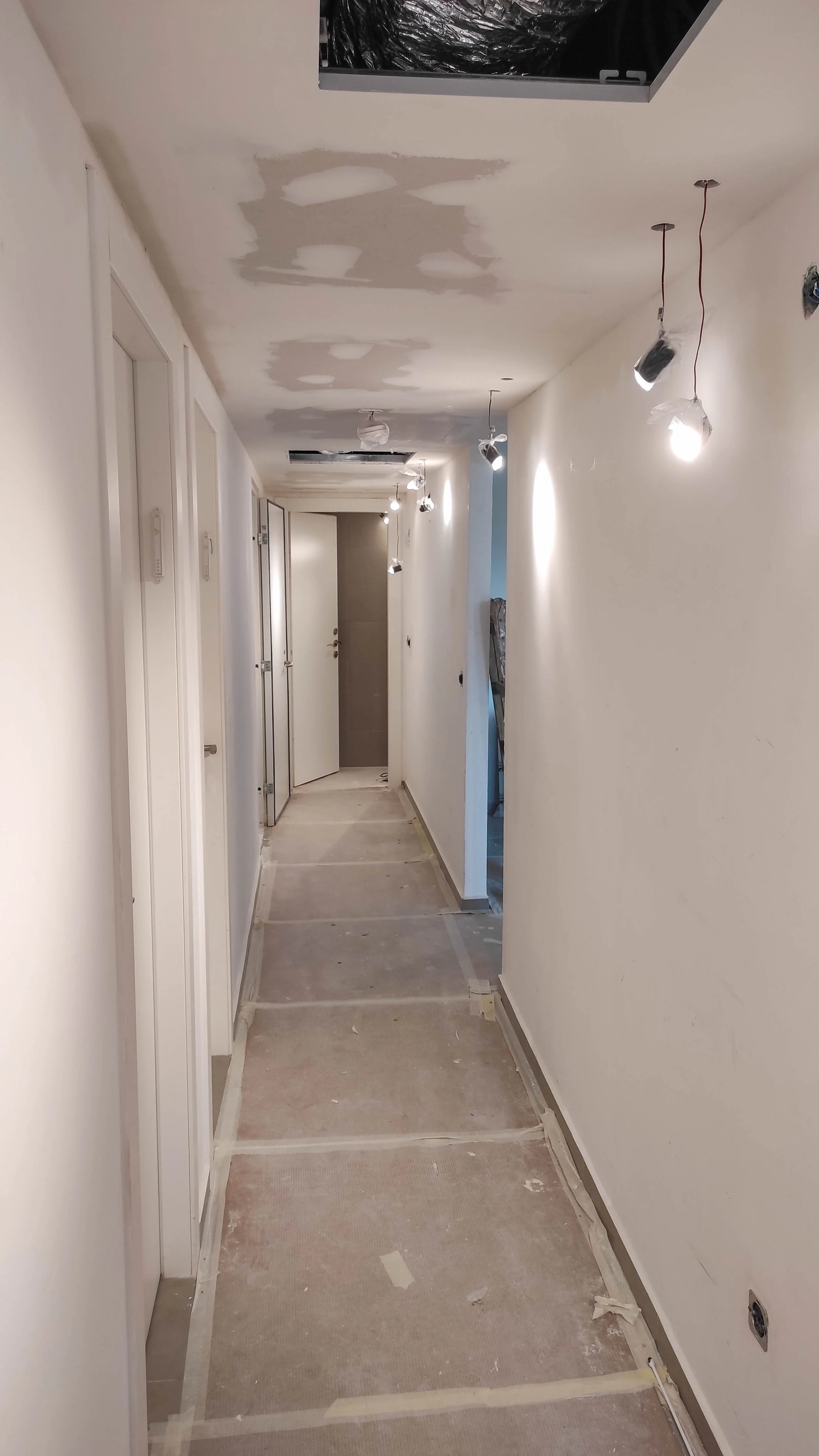 Corridor ceiling drywall repair and patching in progress for a residential project in Bedford