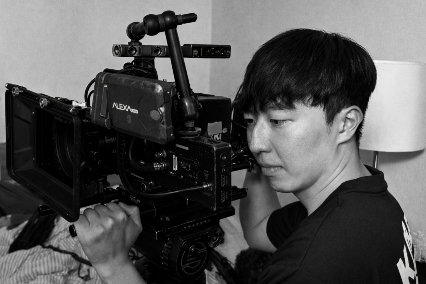 A person operating a professional film camera indoors.