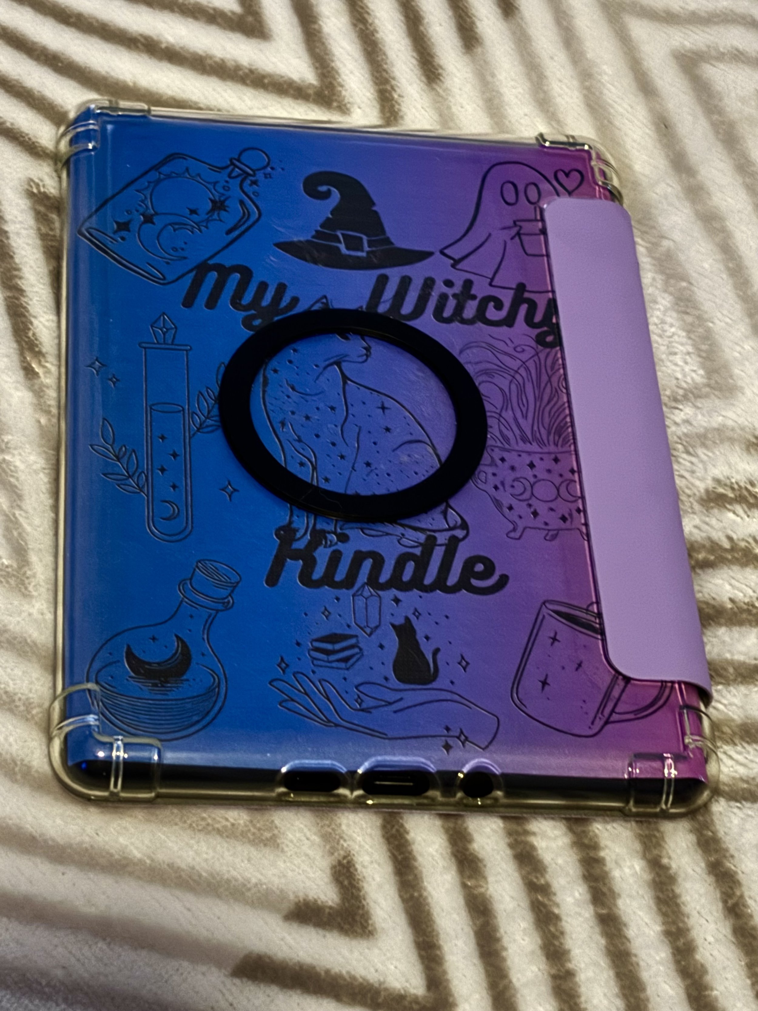 Colorful plastic Kindle cover with witch-themed illustrations and the phrase 'My Witchy Kindle' printed on it.