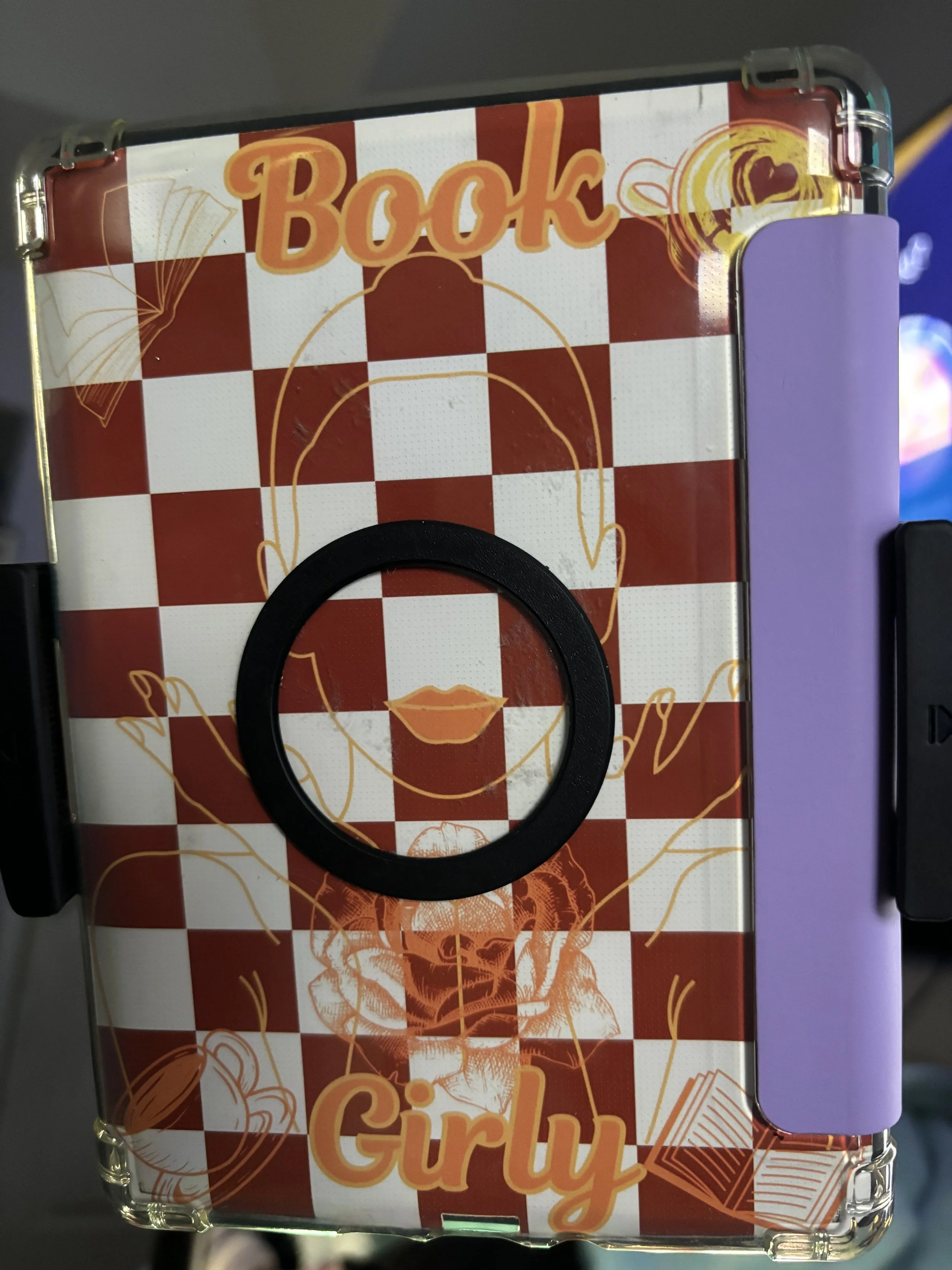 A decorative book cover featuring a red and white checkerboard pattern with illustrations of books, open hands, lips, and a face outline. The text 'Book' and 'Girly' is prominently printed, with the word 'Book' at the top and 'Girly' at the bottom.