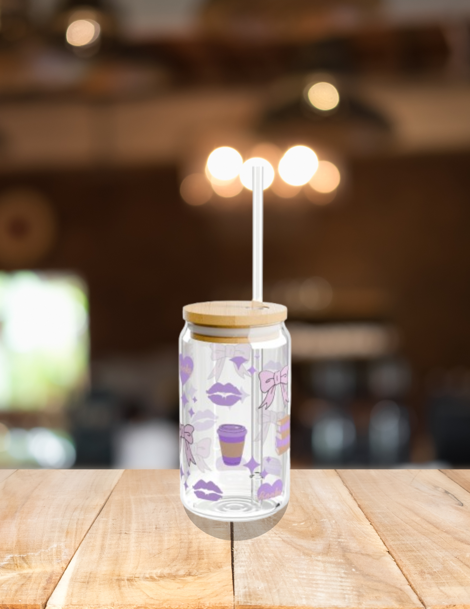A glass jar with a decorative label featuring purple lips, coffee cups, bows, and hearts, with a wooden lid and a plastic straw on a wooden surface. The background is blurred and contains warm lighting.