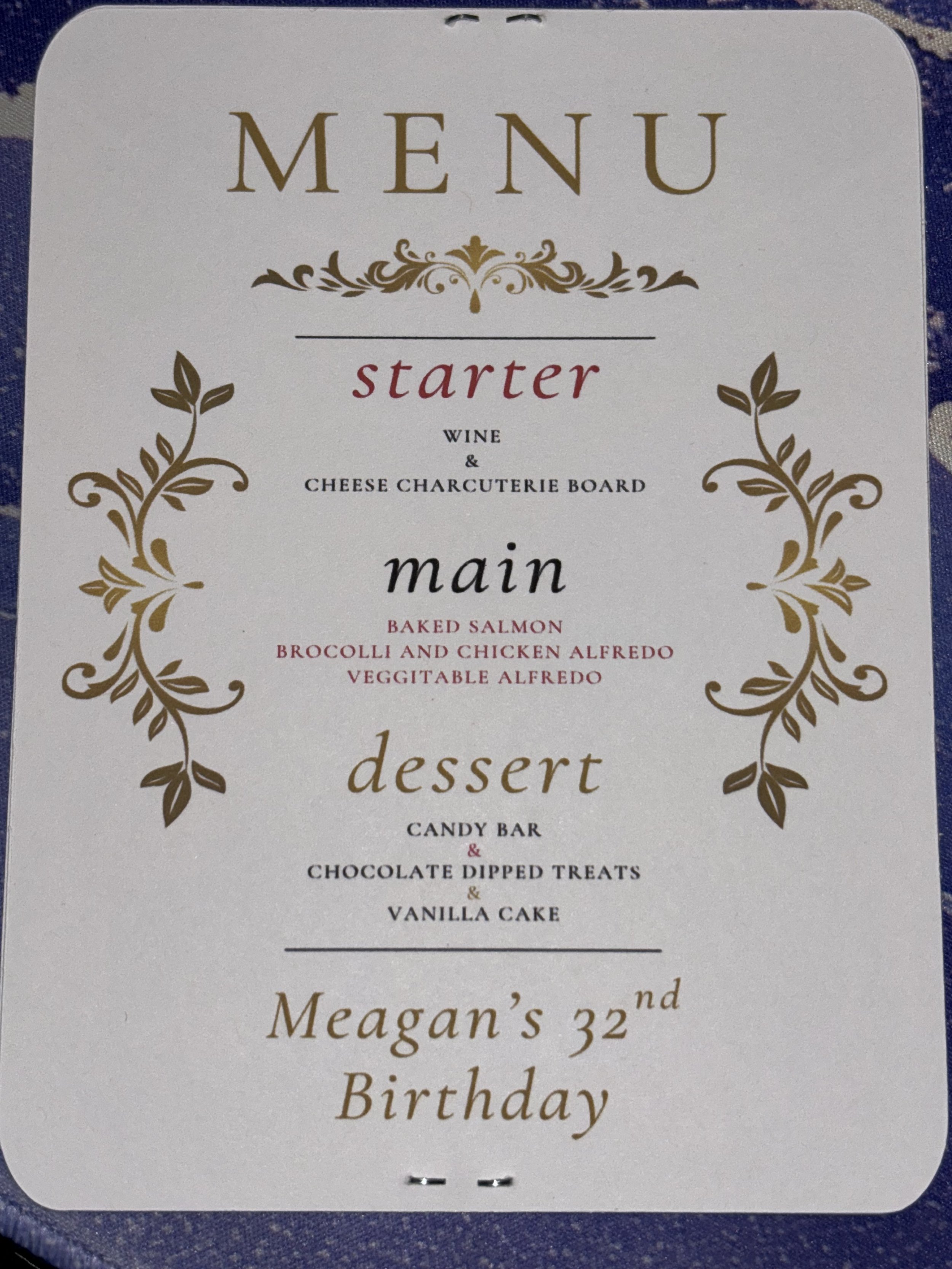 Menu card with gold decorative flourishes, listing starter, main, and dessert options, and a birthday message for Megan's 32nd birthday.