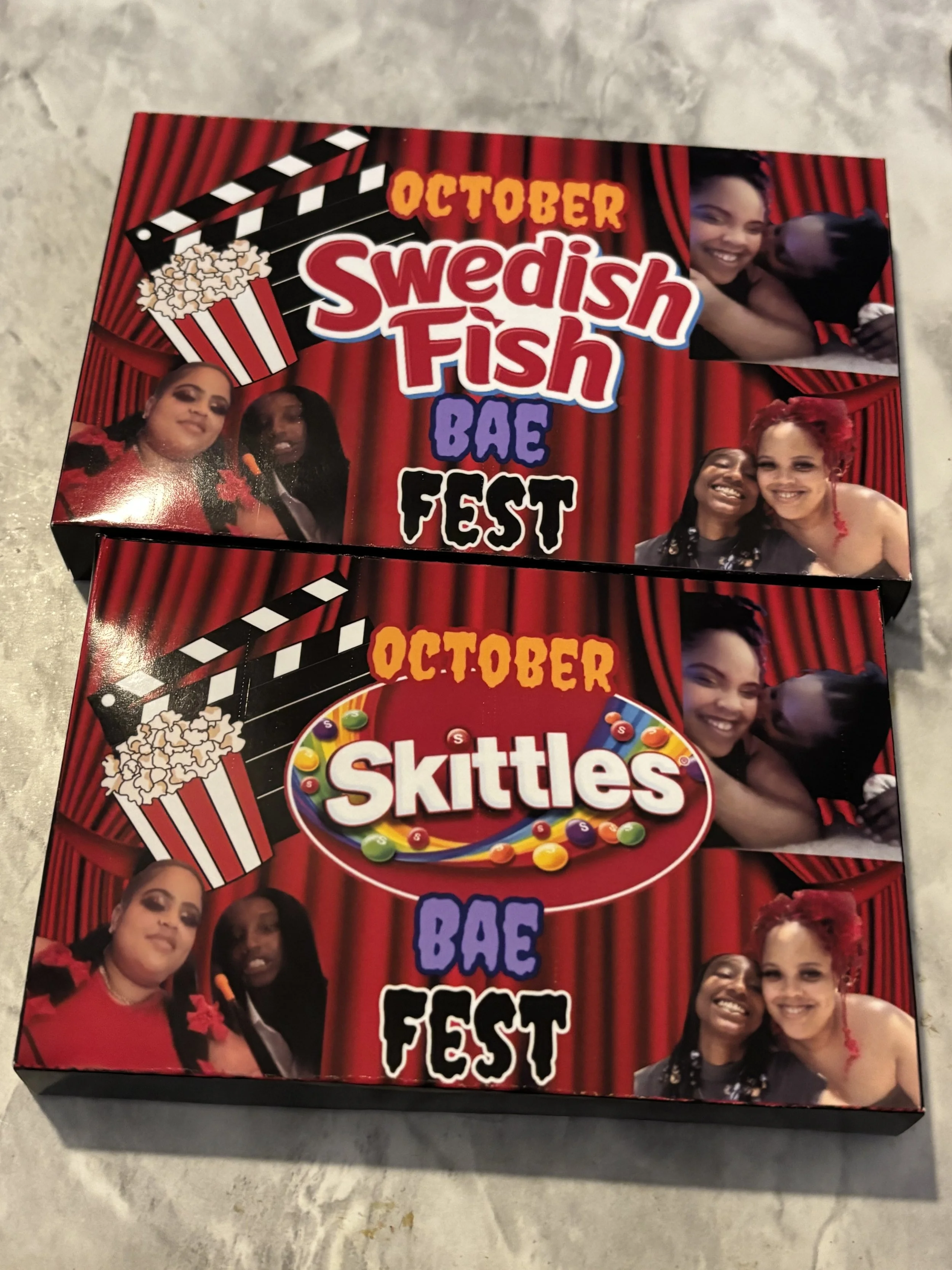 Two boxes of party favors themed for a BA feminist celebration, featuring red curtains, popcorn, a film clapperboard, and photos of women smiling and hugging, with one box labeled 'Swedish Fish BAE Fest' and the other labeled 'Skittles BAE Fest'.