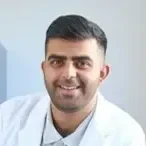 Professional headshot of a smiling man with short dark hair, wearing a light-colored shirt.