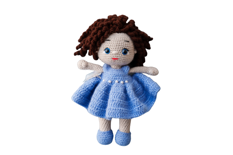 A handmade plush doll with brown curly hair, blue eyes, wearing a blue dress with white beads.