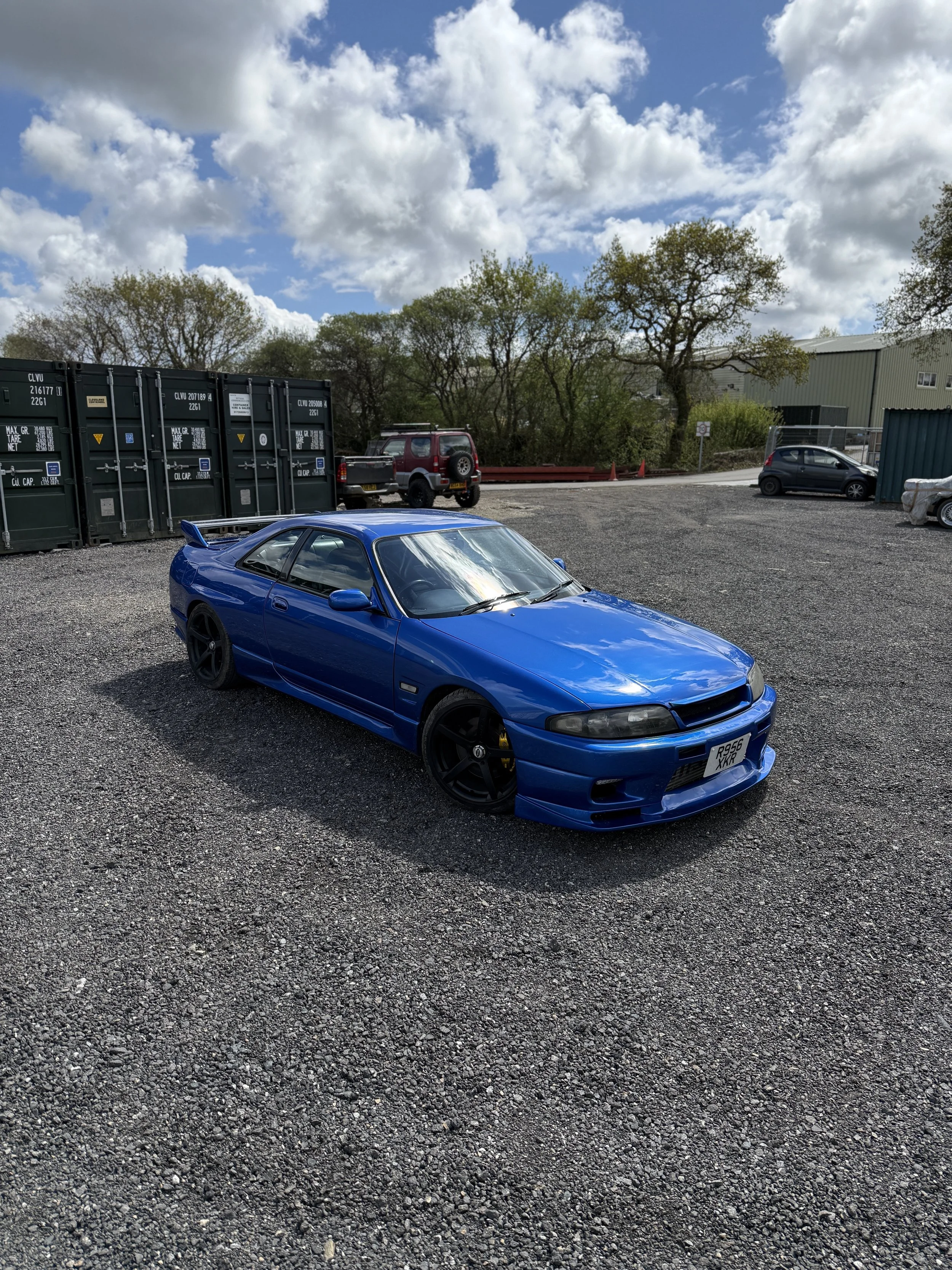 Nissan Skyline r33

A blue sports car with black wheels parked on a gravel lot.