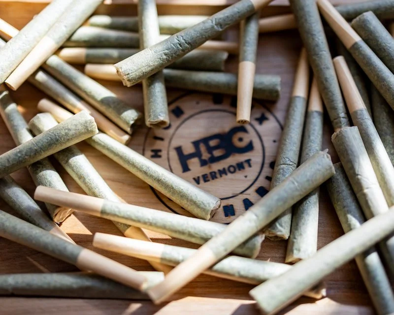 image of cannabis joints on wood platter that says text HBC Vermont