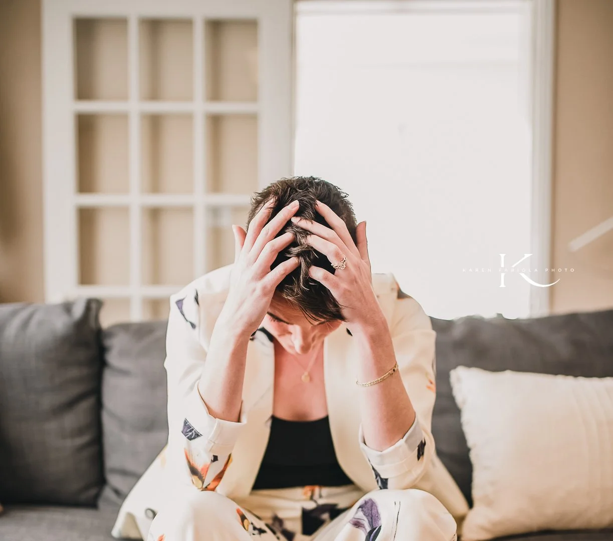 Mujer sosteniéndose la cabeza con ambas manos, en una postura de pausa y recogimiento.