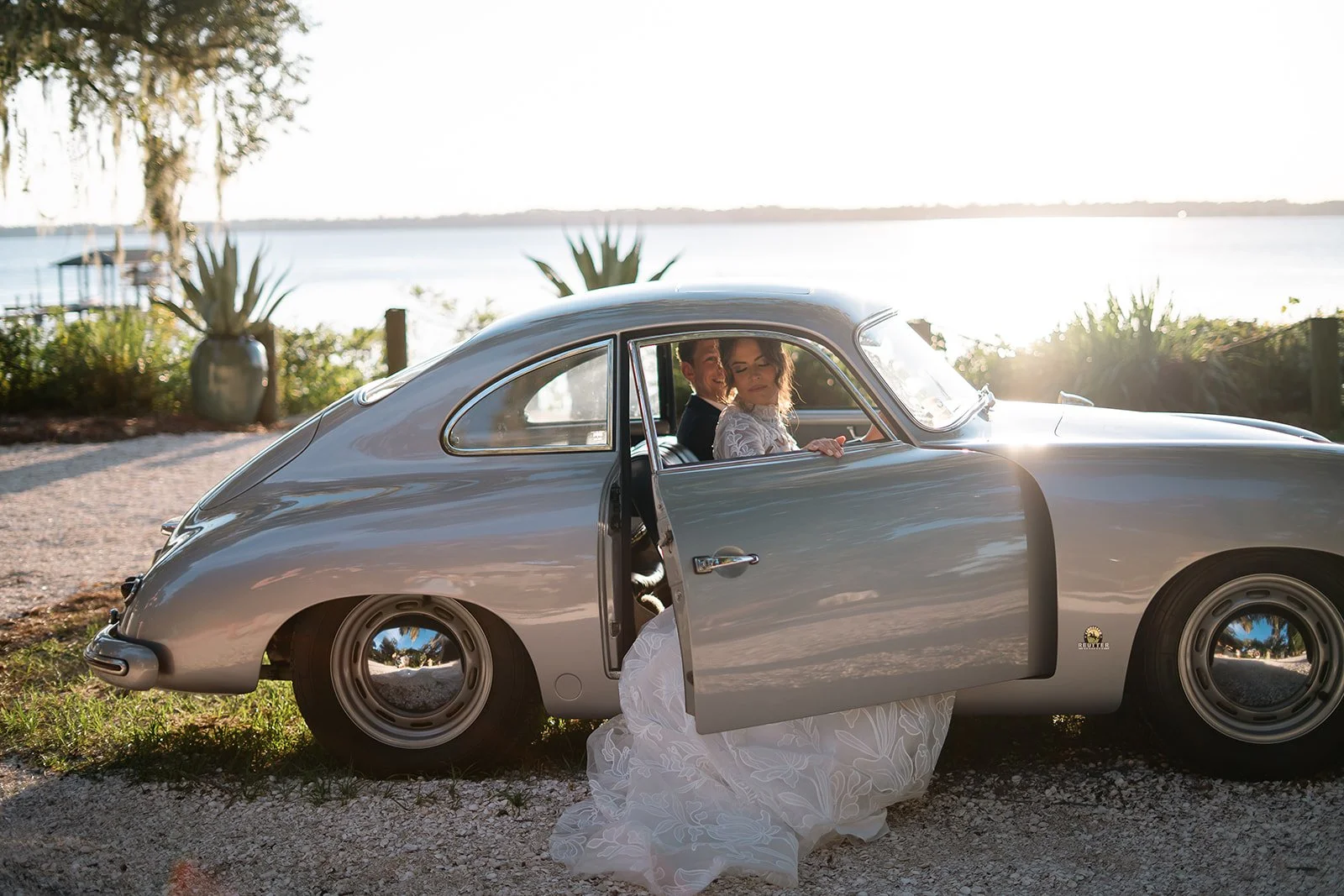 Bride and groom share a romantic kiss by a classic vintage car at sunset during their Cabo Rojo, Puerto Rico elopement – captured by Karen Fabiola Photo, destination wedding photographer.