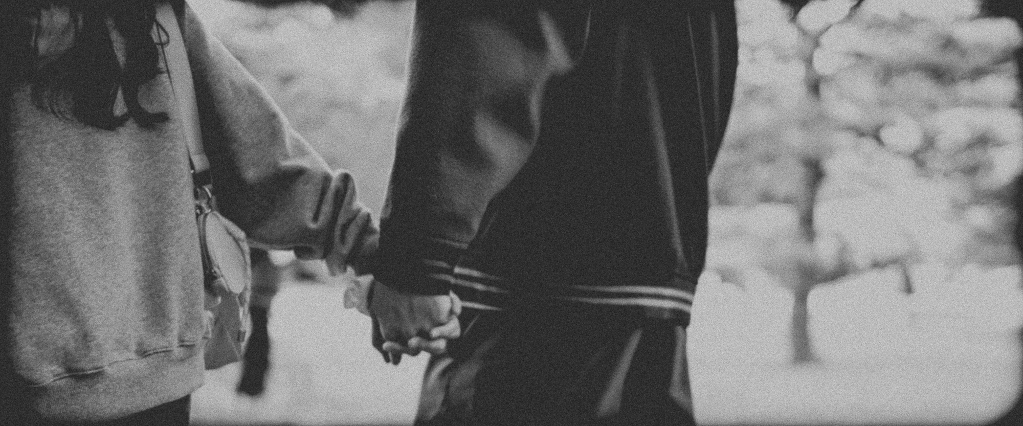 Romantic close-up of a couple holding hands while walking through a serene Tokyo garden, captured by Karen Fabiola Photo. This candid travel moment highlights connection, intimacy, and the beauty of slow living, surrounded by lush greenery and tradit