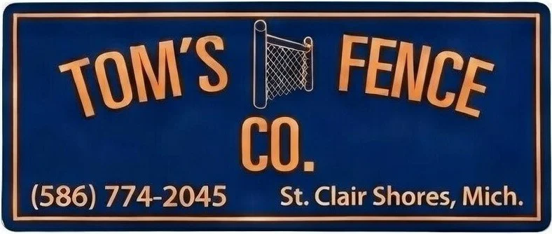 Blue sign with orange text displaying "Tom's Fence Co." and a phone number, located in St. Clair Shores, Michigan.