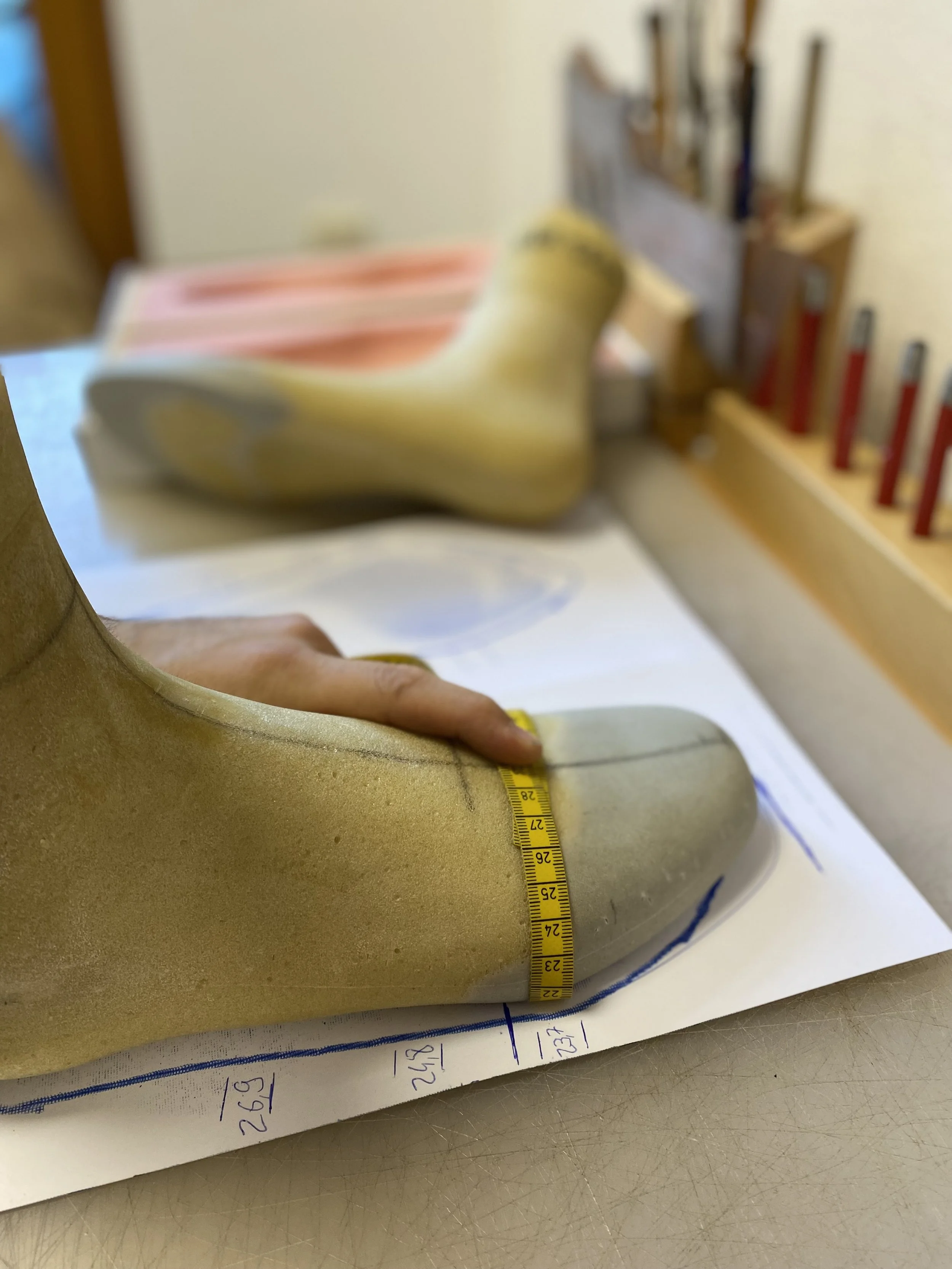 Ein orthopädischer Leisten aus PU-Schaum wo mit einem Maßband die Maße kontrolliert werden. Dieser Leisten wird für den Maßschuhbau verwendet. Es kommt auf genaues arbeiten beim Leisten bau drauf an für ein perfektes Ergebnis